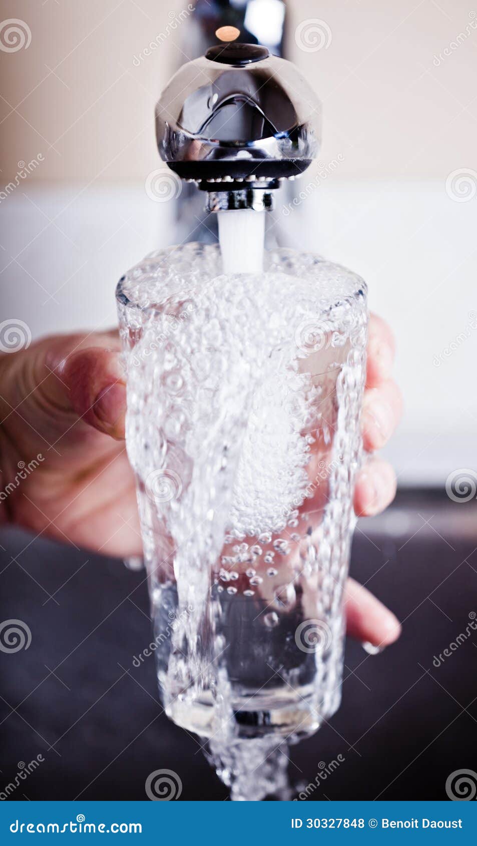 very thirsty man filling an overflowing glass of water