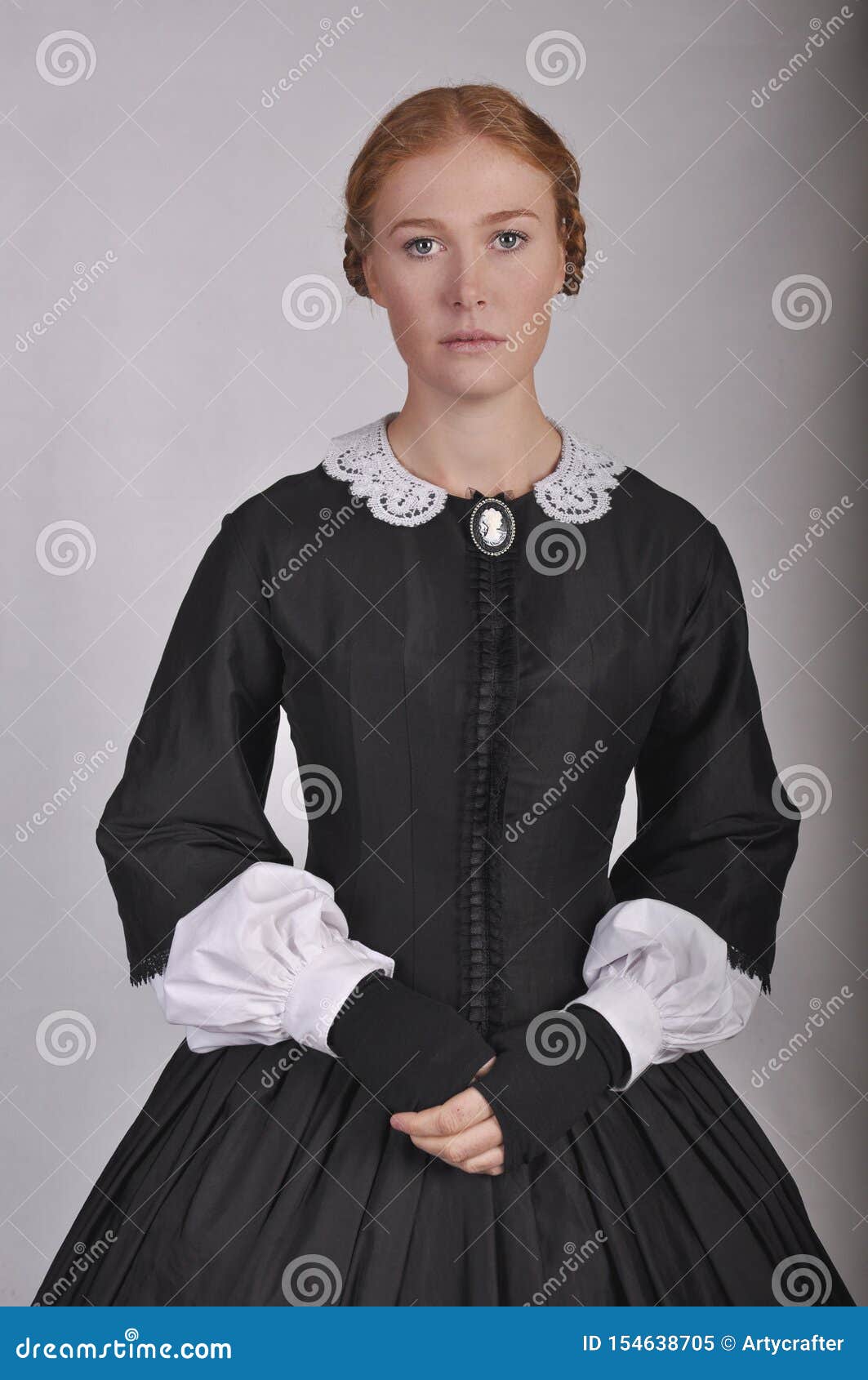 victorian woman in black ensemble  on studio backdrop