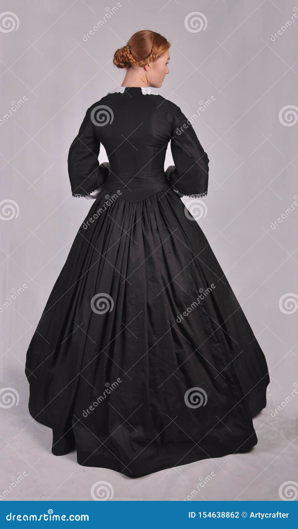 victorian woman in black ensemble  on studio backdrop