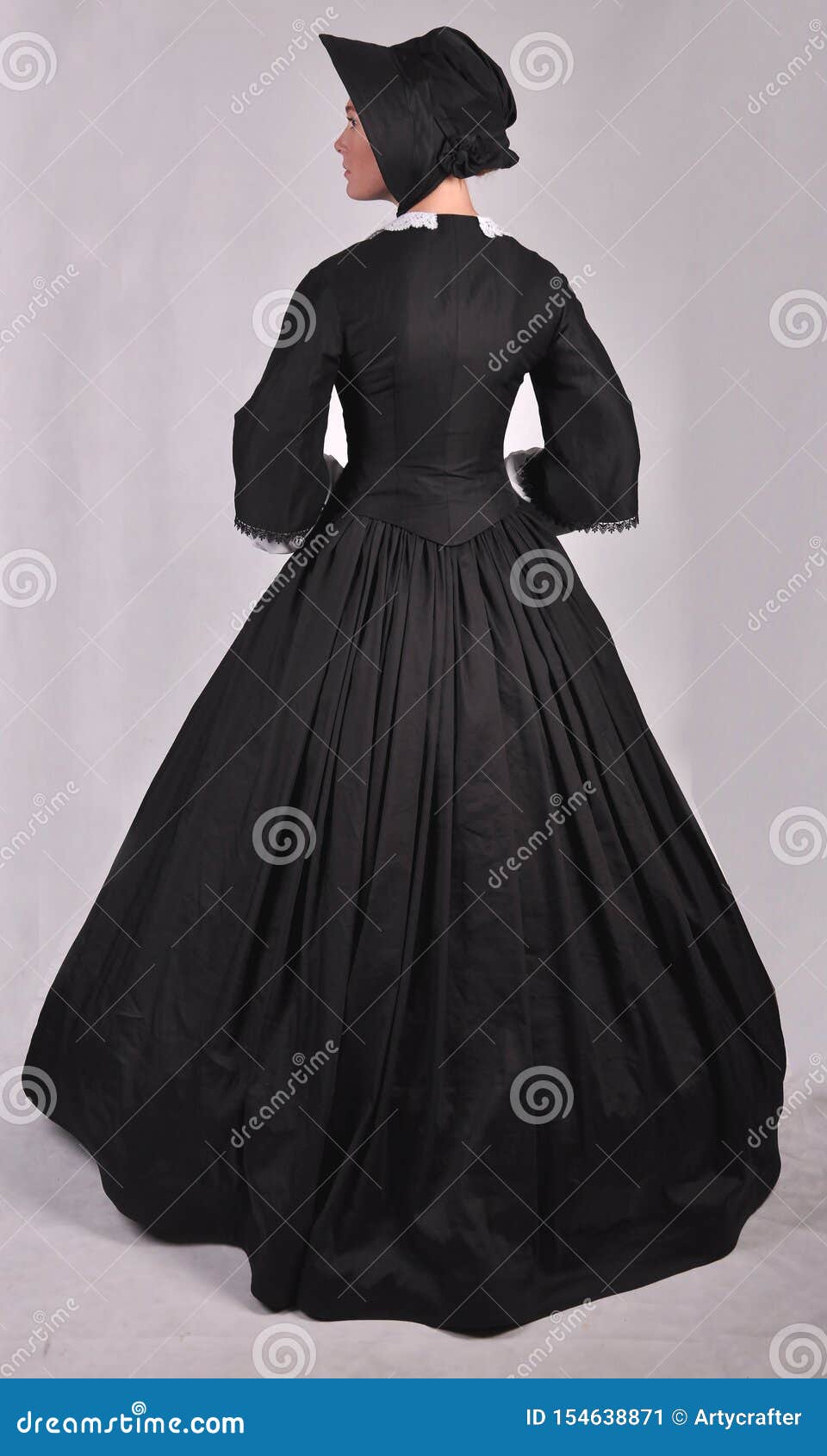 victorian woman in black ensemble  on studio backdrop