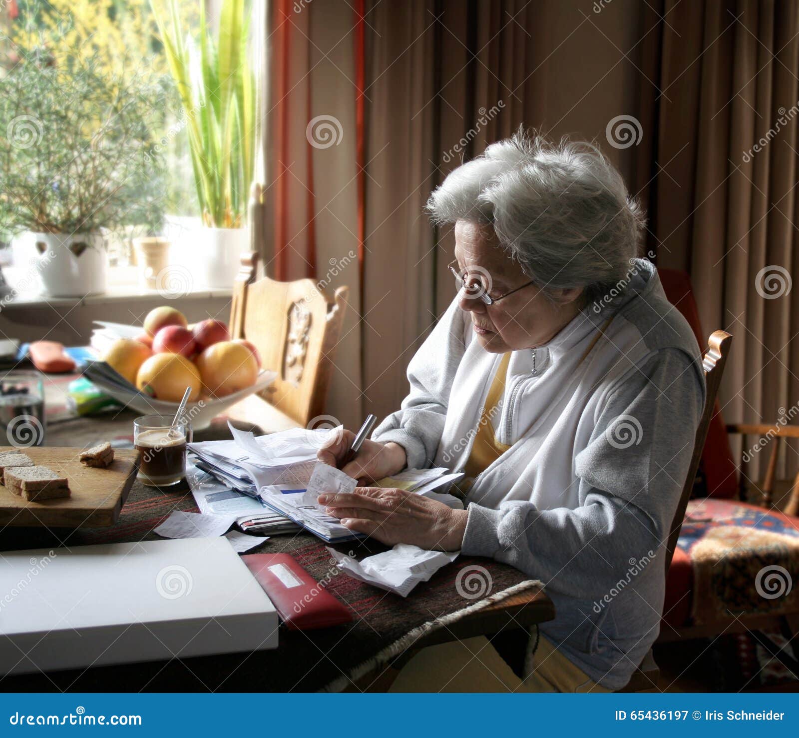 Vida en la Seguridad Social. Mujer mayor que equilibra sus libros para hacer que los extremos se encuentran