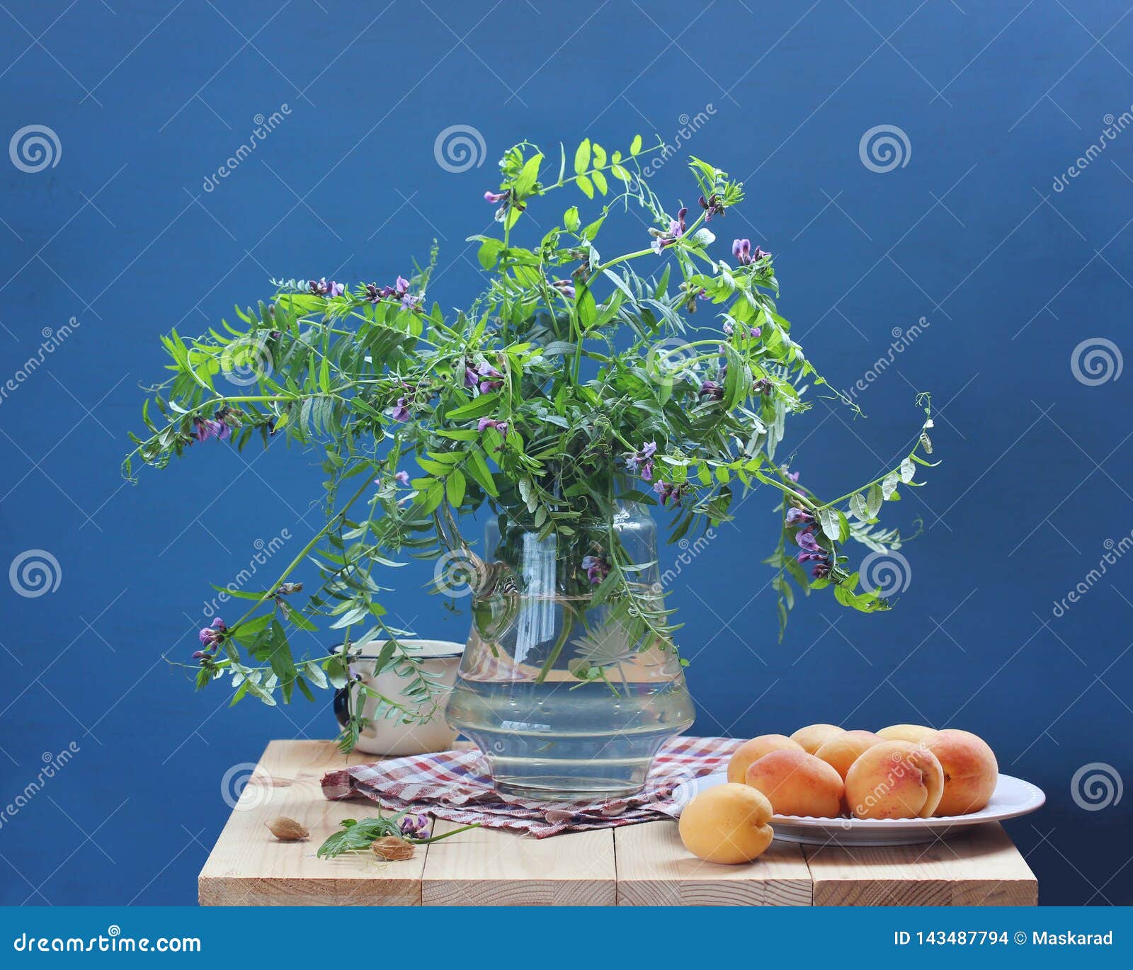 Vida imóvel do verão com flores e fruto em um fundo azul ramalhete e abricós