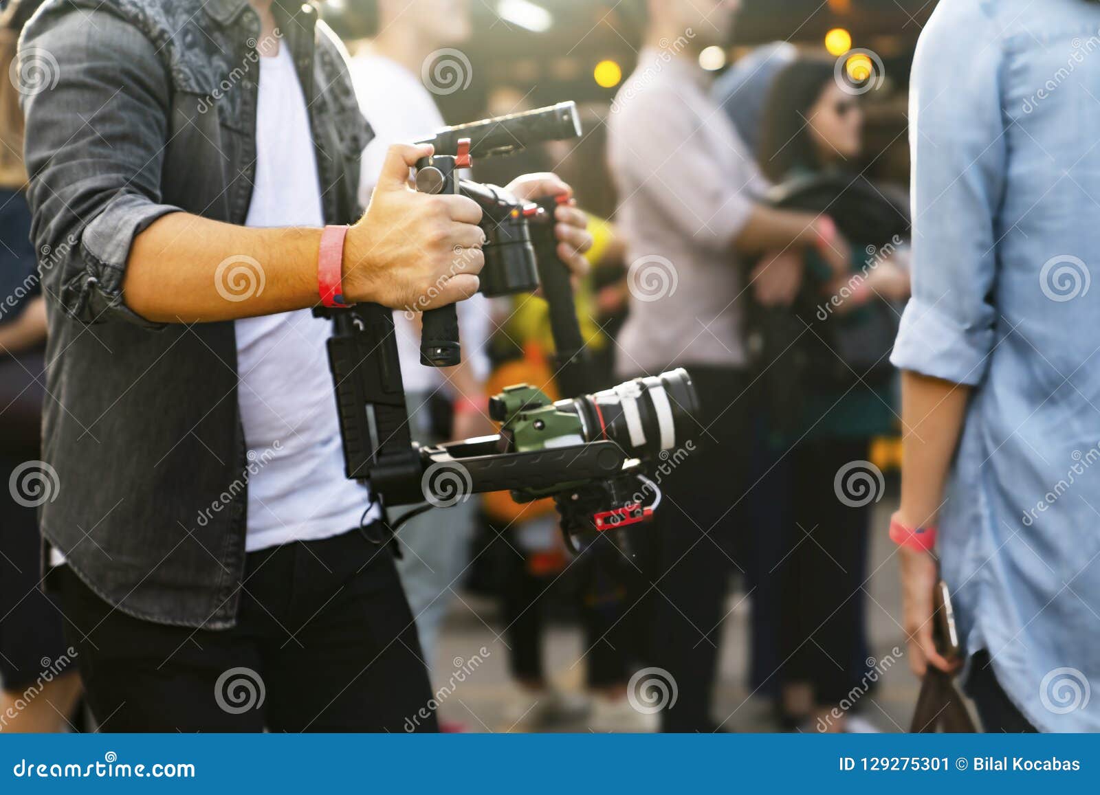 Videographer with Gimball Video DSLR in an Event among People Stock
