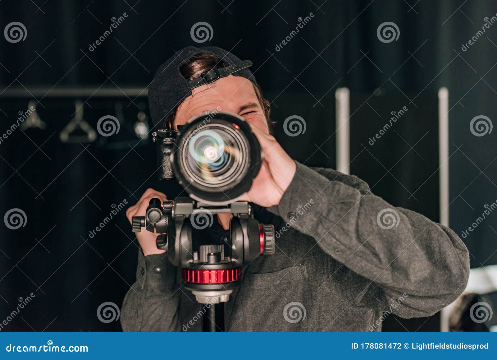 Videographer Looking through Camera while Working Stock Photo Image