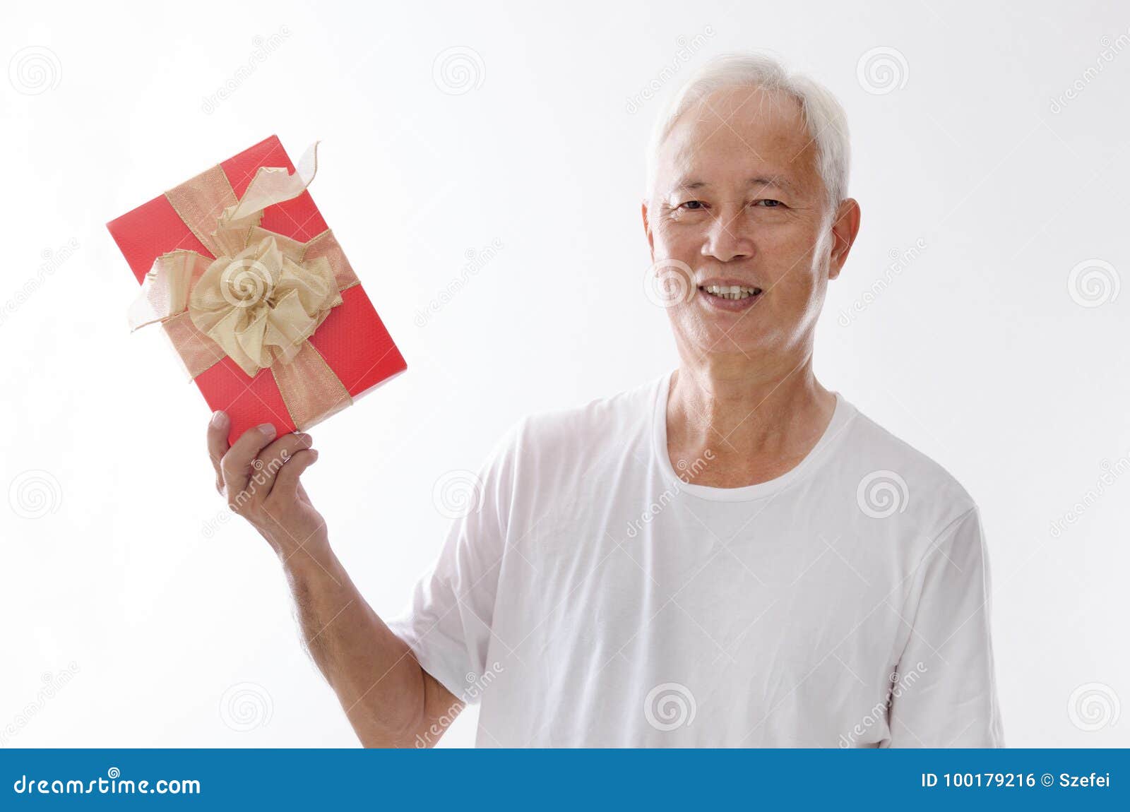 Viejo hombre asiático que sostiene la caja de regalo. Retrato de la vieja mano asiática del hombre que sostiene una caja de regalo, aislado en el fondo blanco