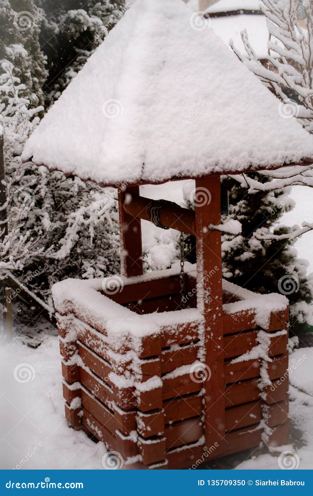 Viejo vintage bien con un tejado en la nieve en invierno. Viejo vintage de madera bien de caoba con un tejado en la nieve en invierno