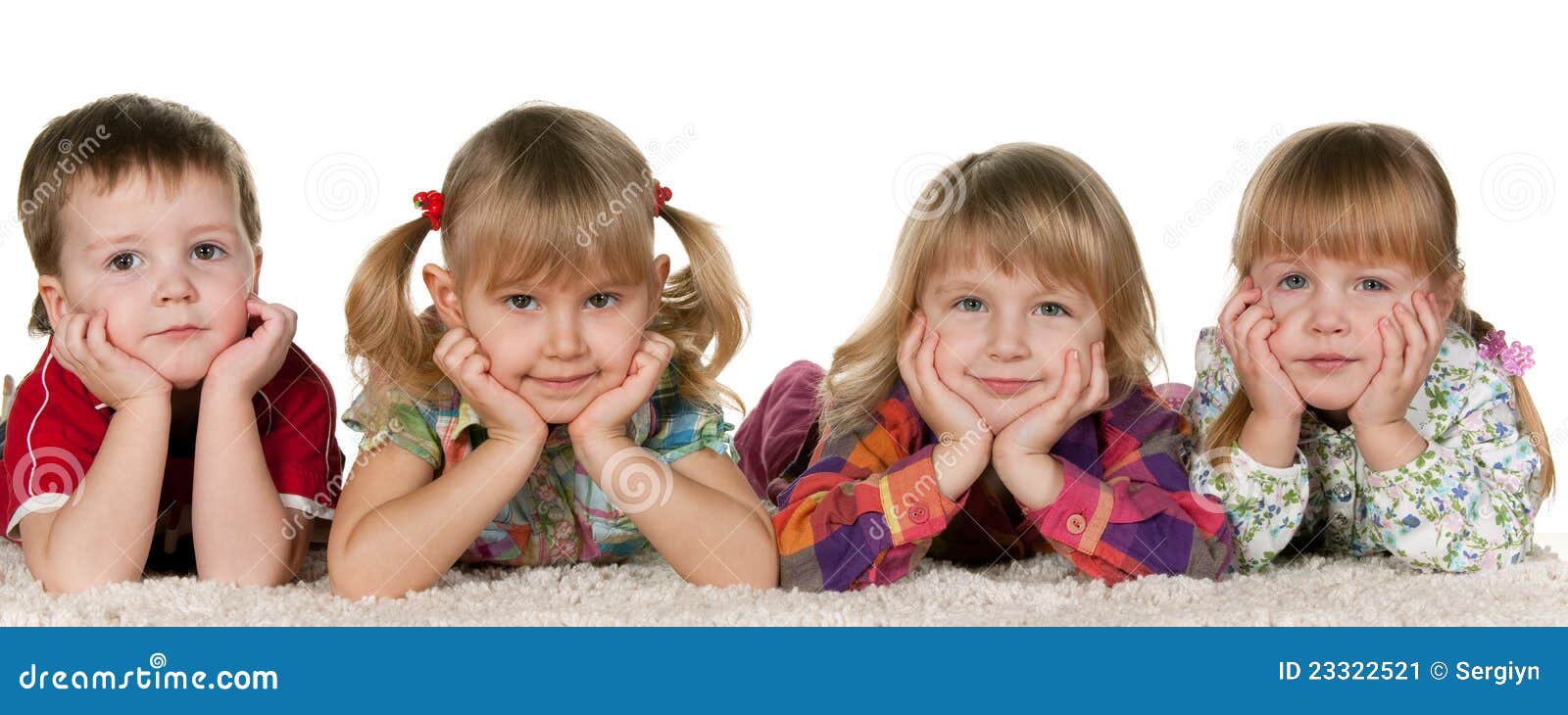 Vier kinderen die op het tapijt liggen. Een kleine jongen ligt bij drie meisjes op het tapijt; geïsoleerdp op de witte achtergrond