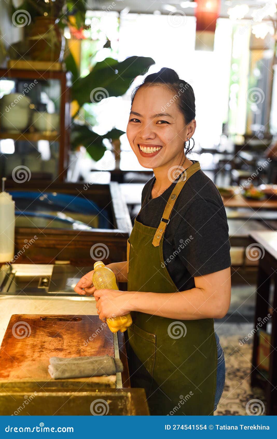 Vietnamese Happy Waitress Working in a Kitchen of a Cafe Stock Photo