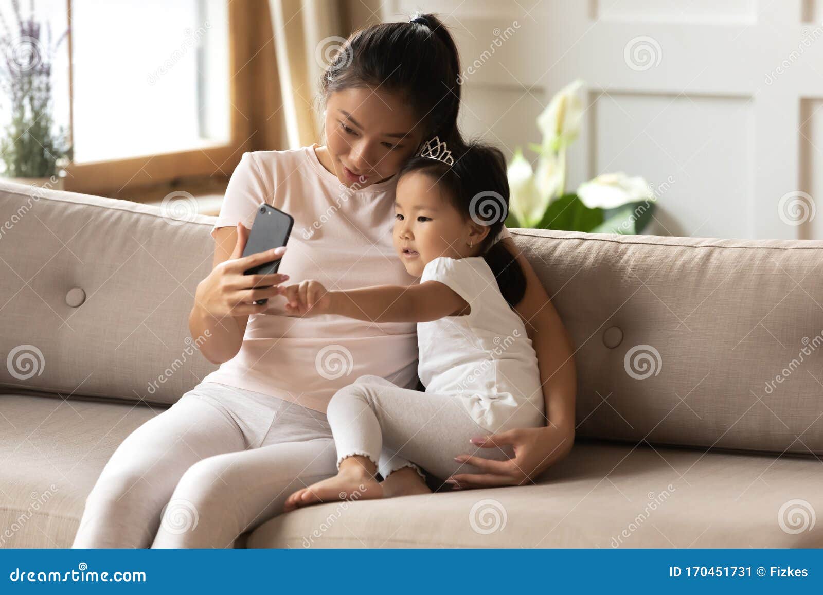 Happy Asian Mom And Little Daughter Make Selfie Together Stoc