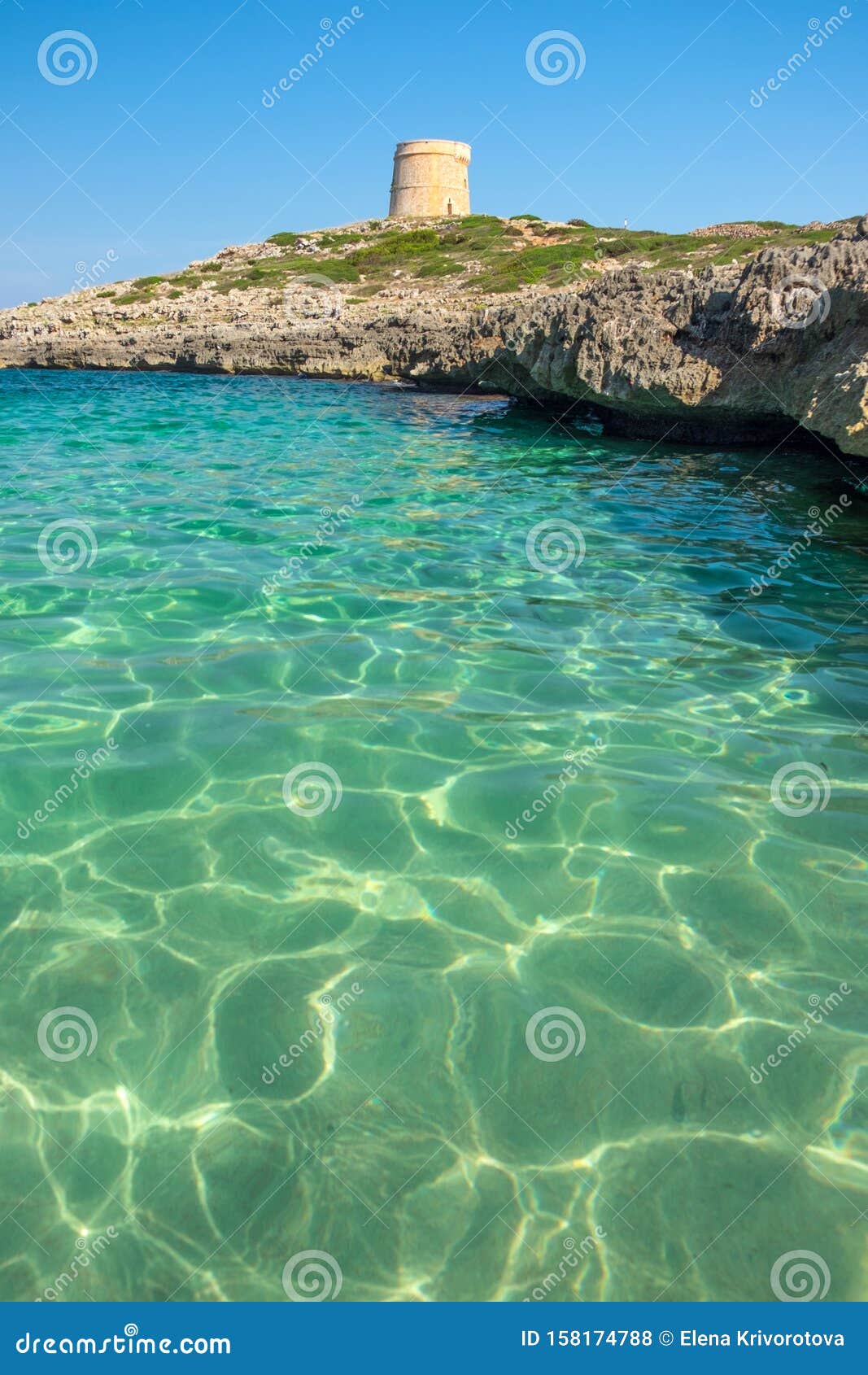 view on the beach calo roig and the defense tower alcaufar on menorca