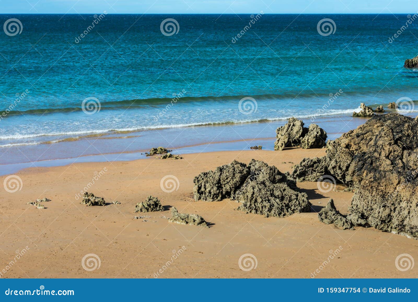 view of the beach with rocks and sand between cliffs