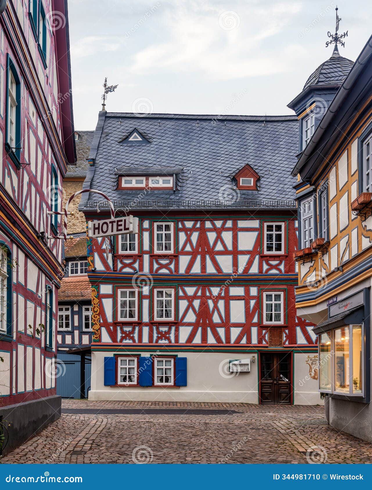 view of colorful buildings in a cobblestone street with a "hotel" sign on the left, at the daytime
