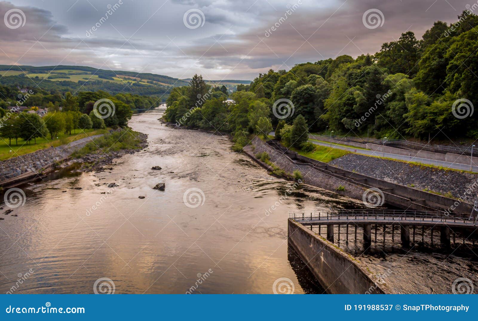 a view down the river tummel at sunset from pitlochry dam, on a cloudy evening