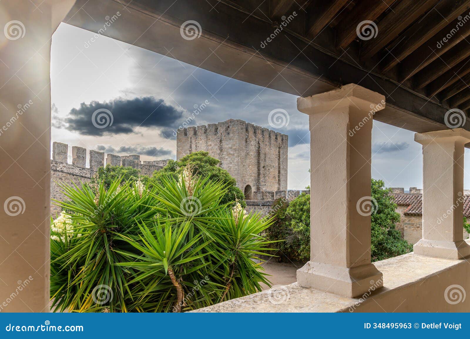 view of elvas castles historic stone tower surrounded by lush plants with covered area and column frame