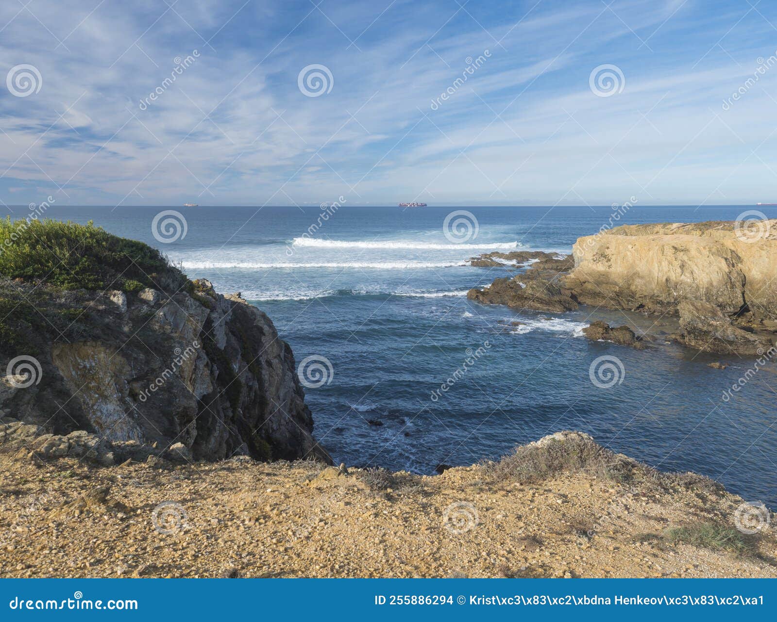 view of empty praia selvagem sand beach with ocean waves and sharp rock and cllifs at wild rota vicentina coast near