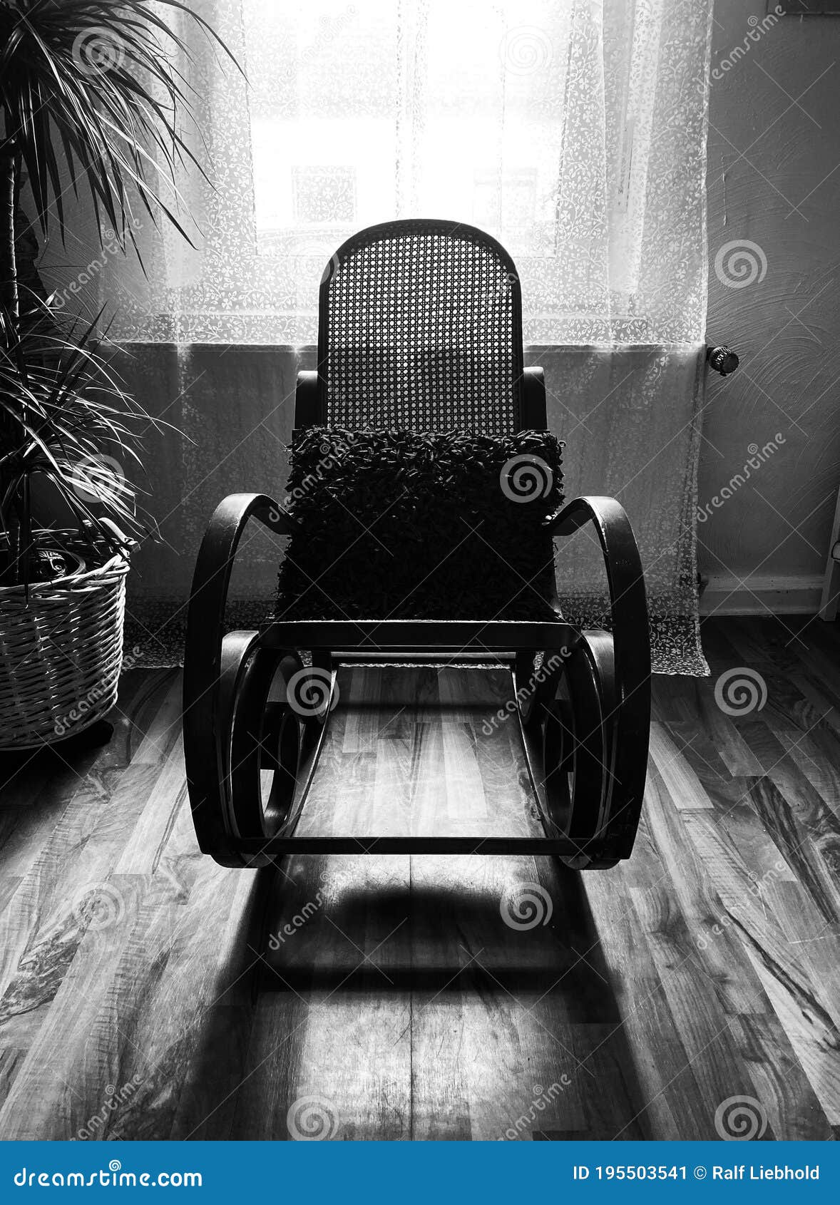 view on empty rocking chair in living room with shadow from backlight of window - grieve and loss of loved person concept