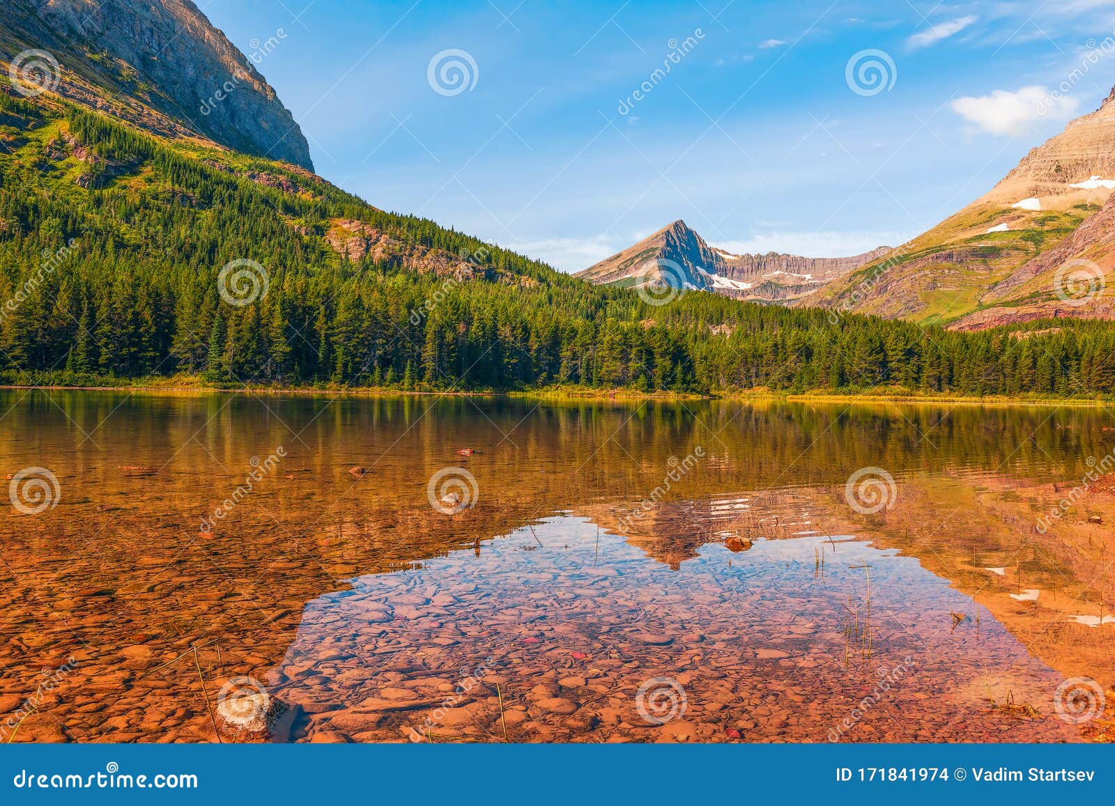 view of fishercap lake and the surrounding mountains in autumn.glacier national park.montana