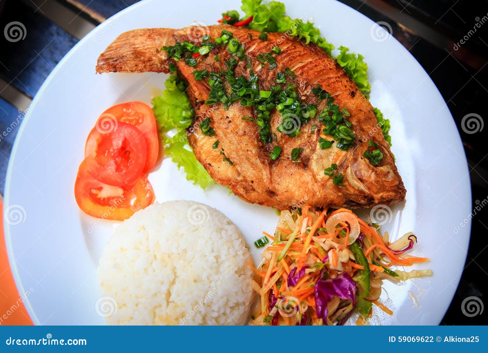 View of Fried Fish with Rice Vegetables on White Plate Stock Photo