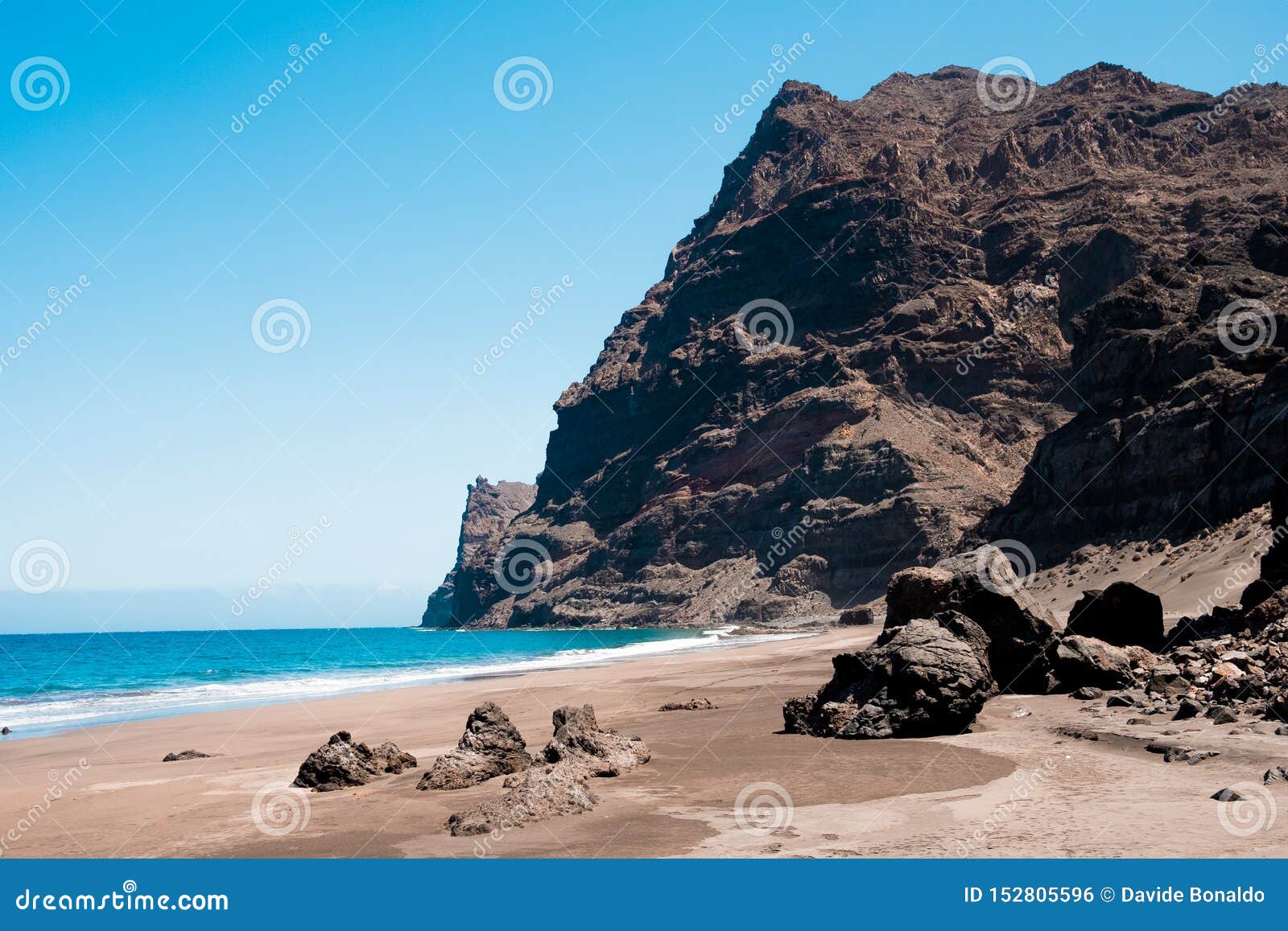 scenic view of gui gui beach in gran canaria island in spain with spectacular mountains landscape and clear blue sky and sandy