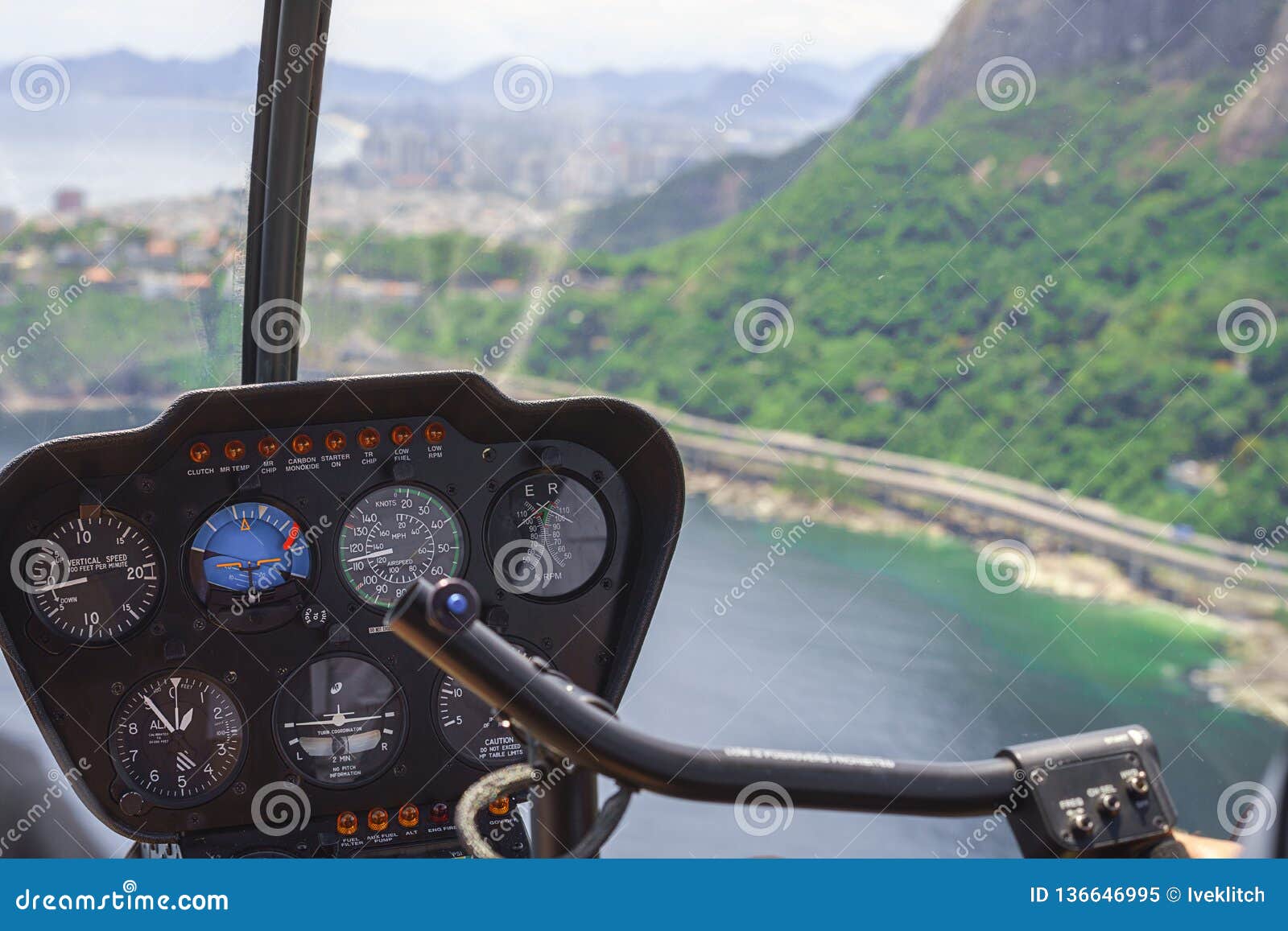 view from a helicopter cockpit flying over rio de janeiro. cockpit with instruments panel. captain in the aircraft cockpit.