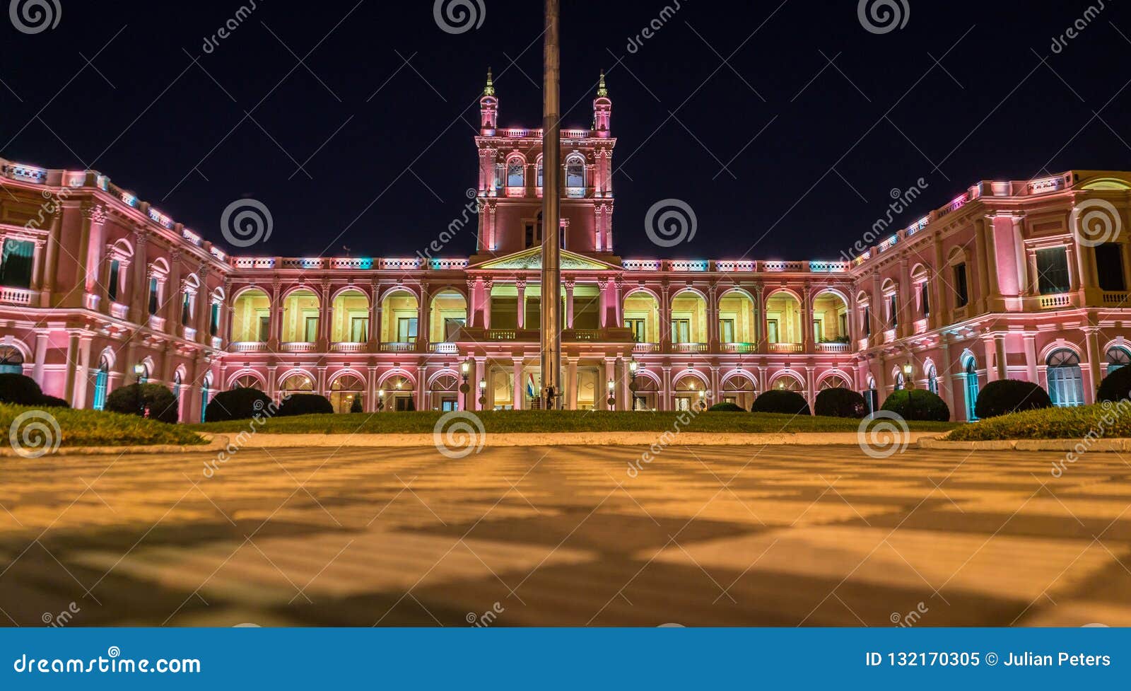 view on illuminated pink presidential palace in asuncion, paraguay at night