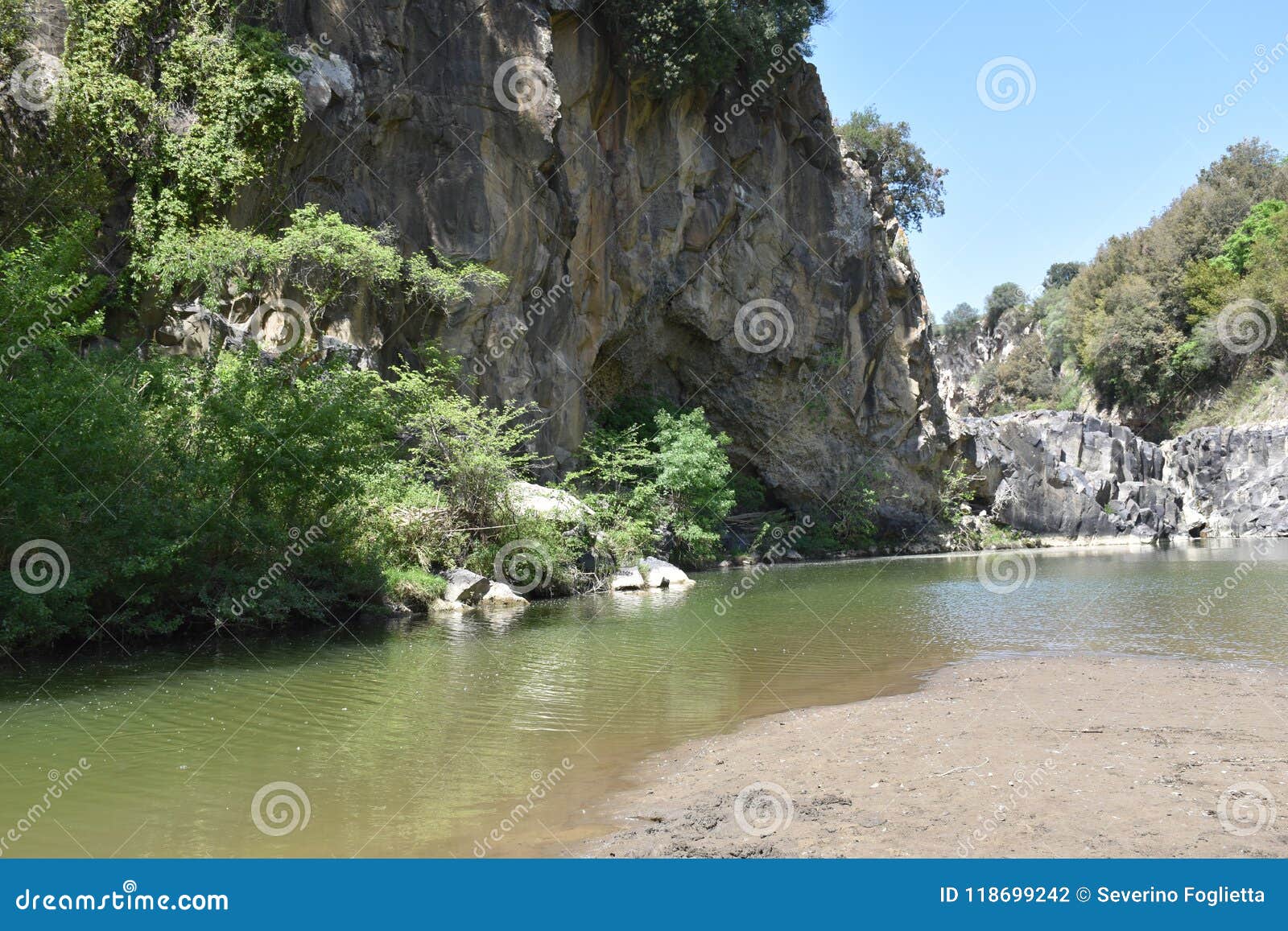 view of the lake and beach with sand and stones