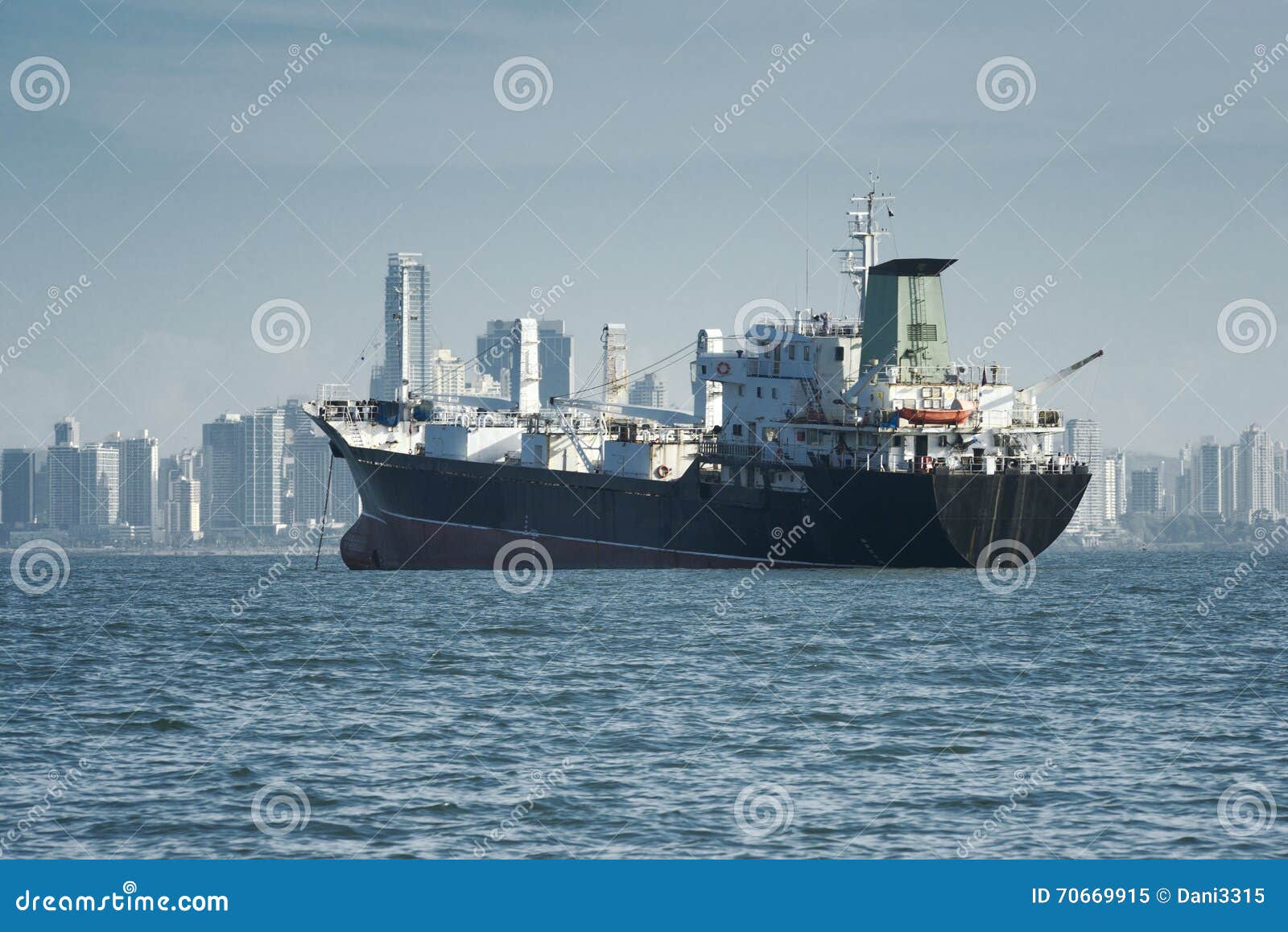 View of a Large Cargo Ship Anchored and the City Skyline at the