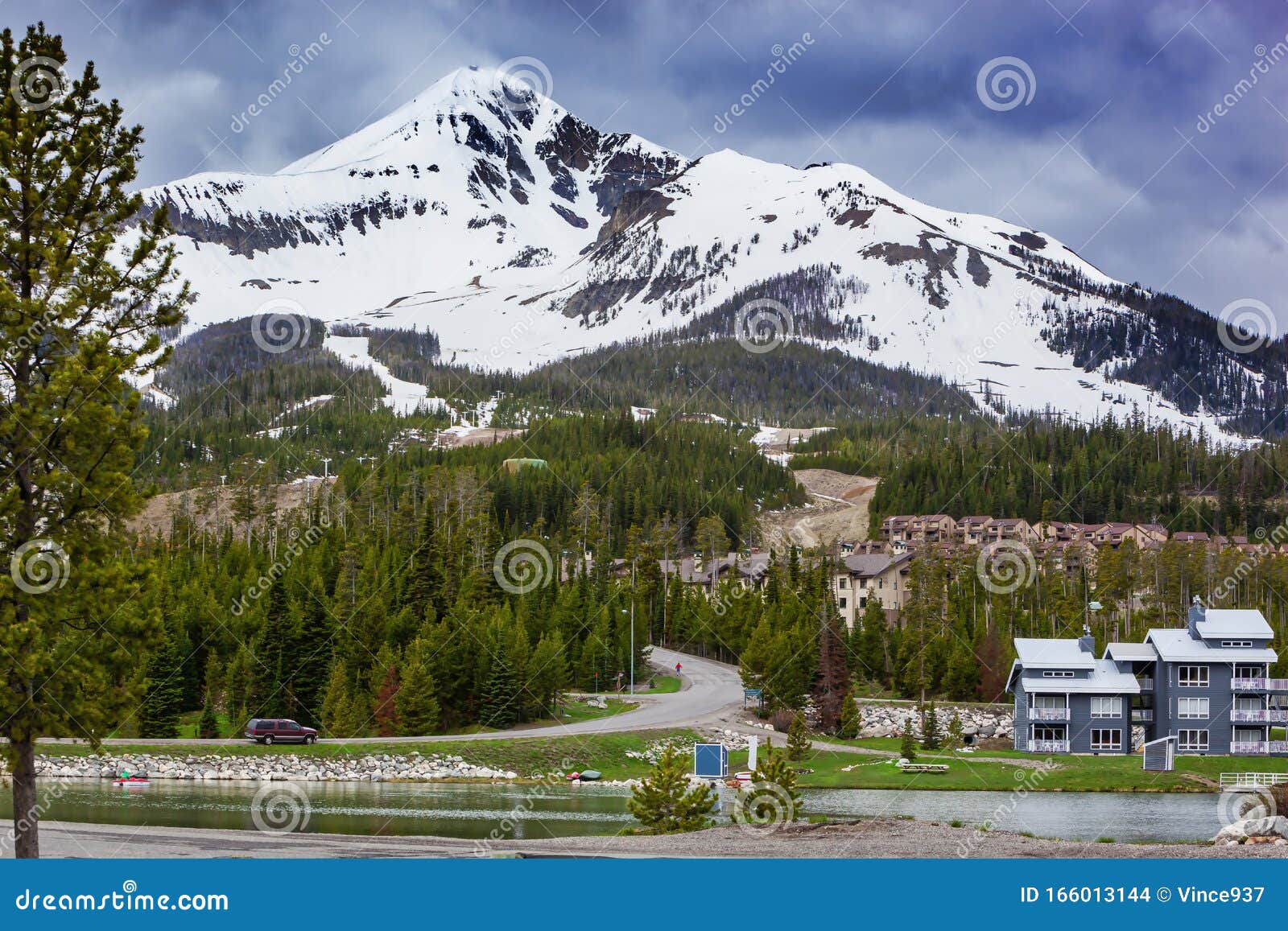 view of lone mountain with buildings and pine trees on the foot of the mountain, big sky, montana, usa