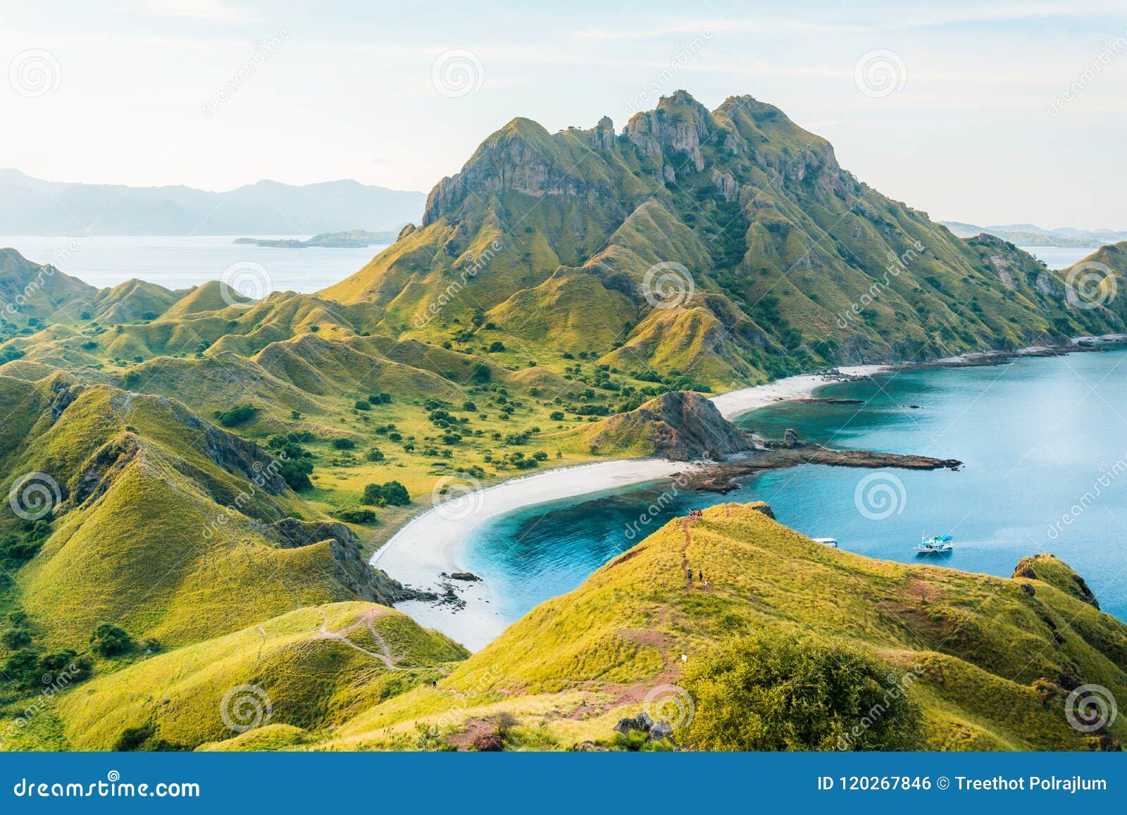 view of padar island in a cloudy evening with blue water surface and tourist boats