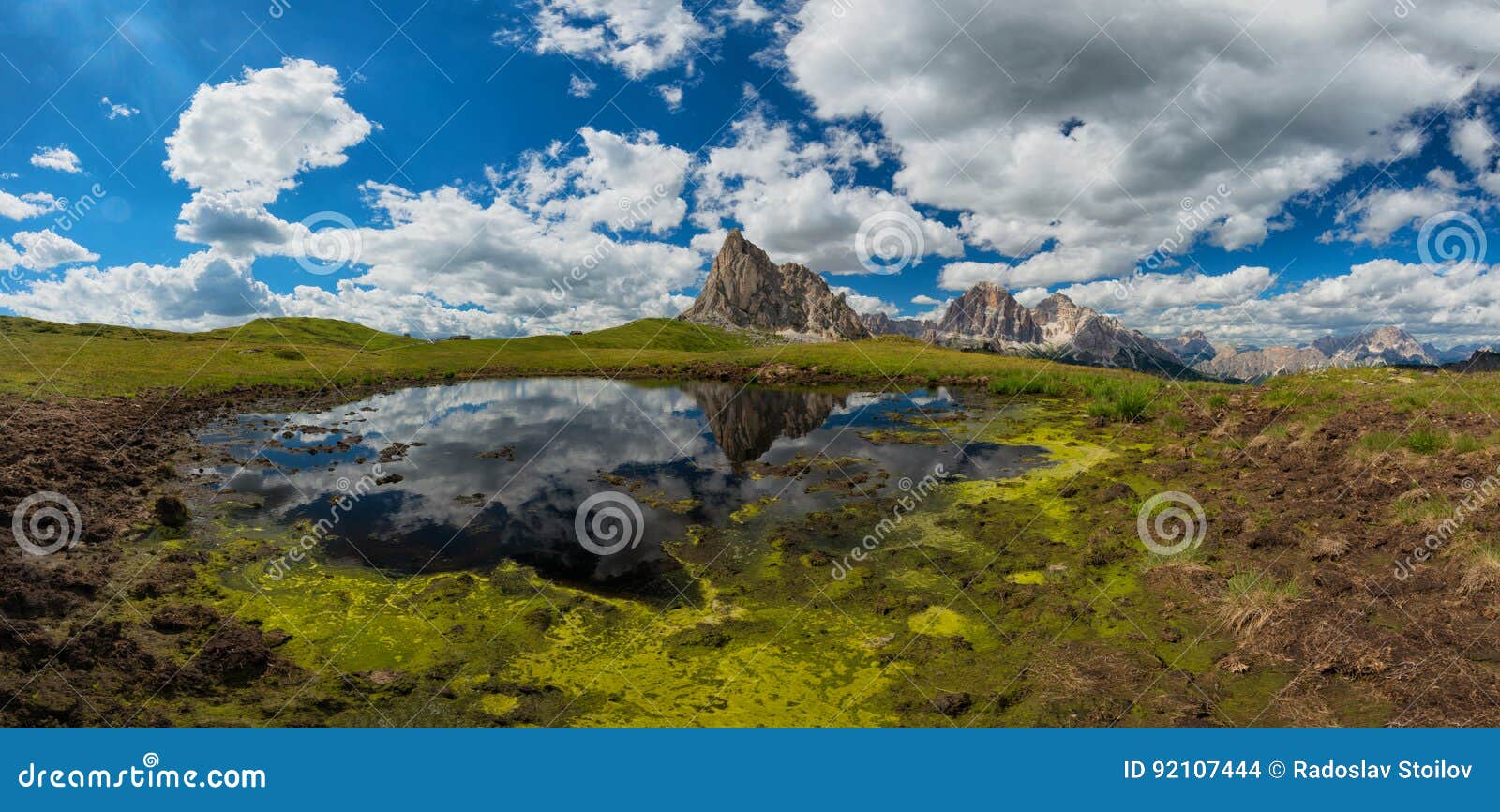 view from passo giau to mount ra gusela from nuvolau gruppe and tofana or le tofane gruppe with clouds, mountain mirroring in lake