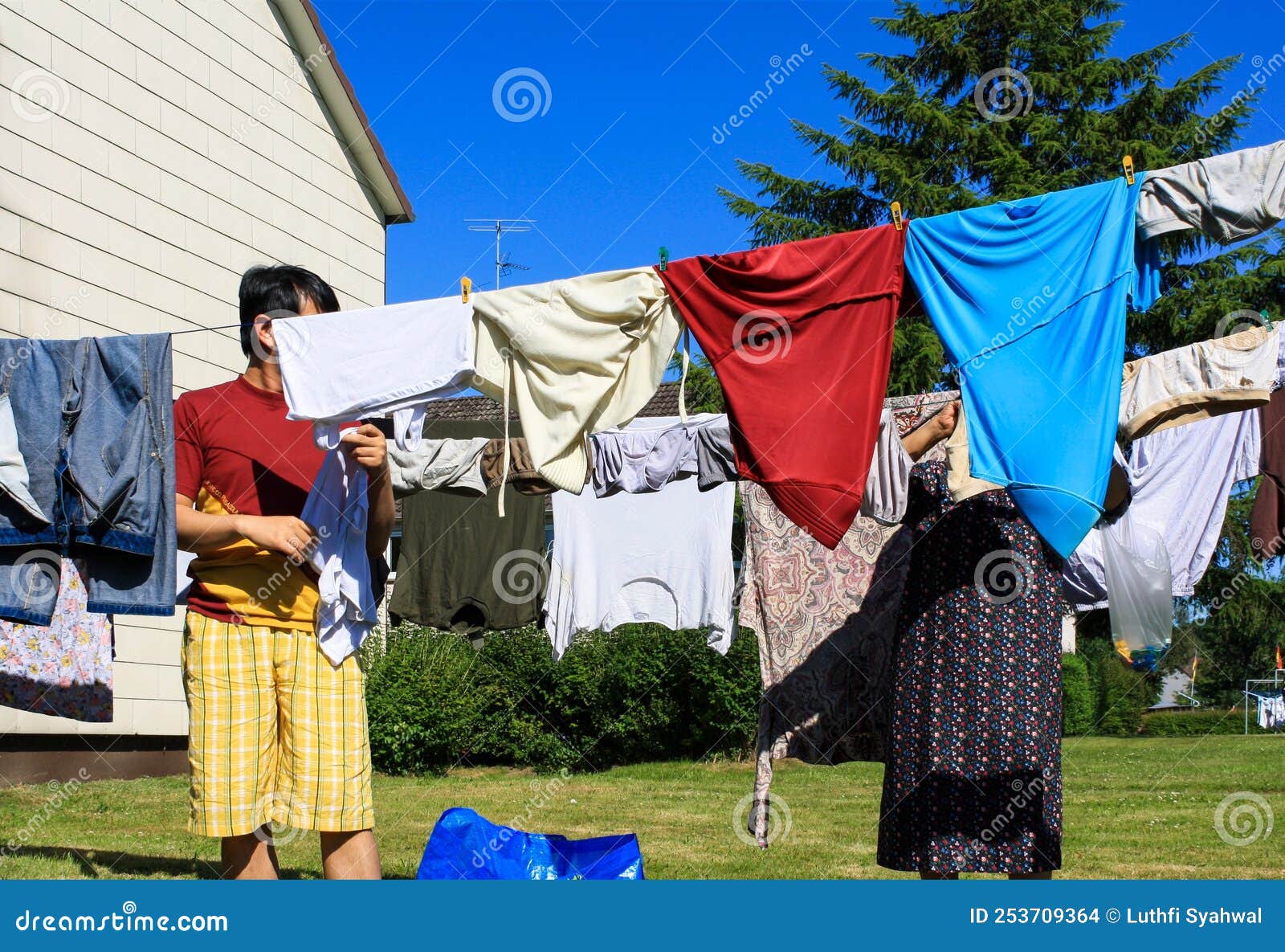 View of People Hanging Laundry on Clothesline in Backyard Stock Photo -  Image of family, fresh: 253709364