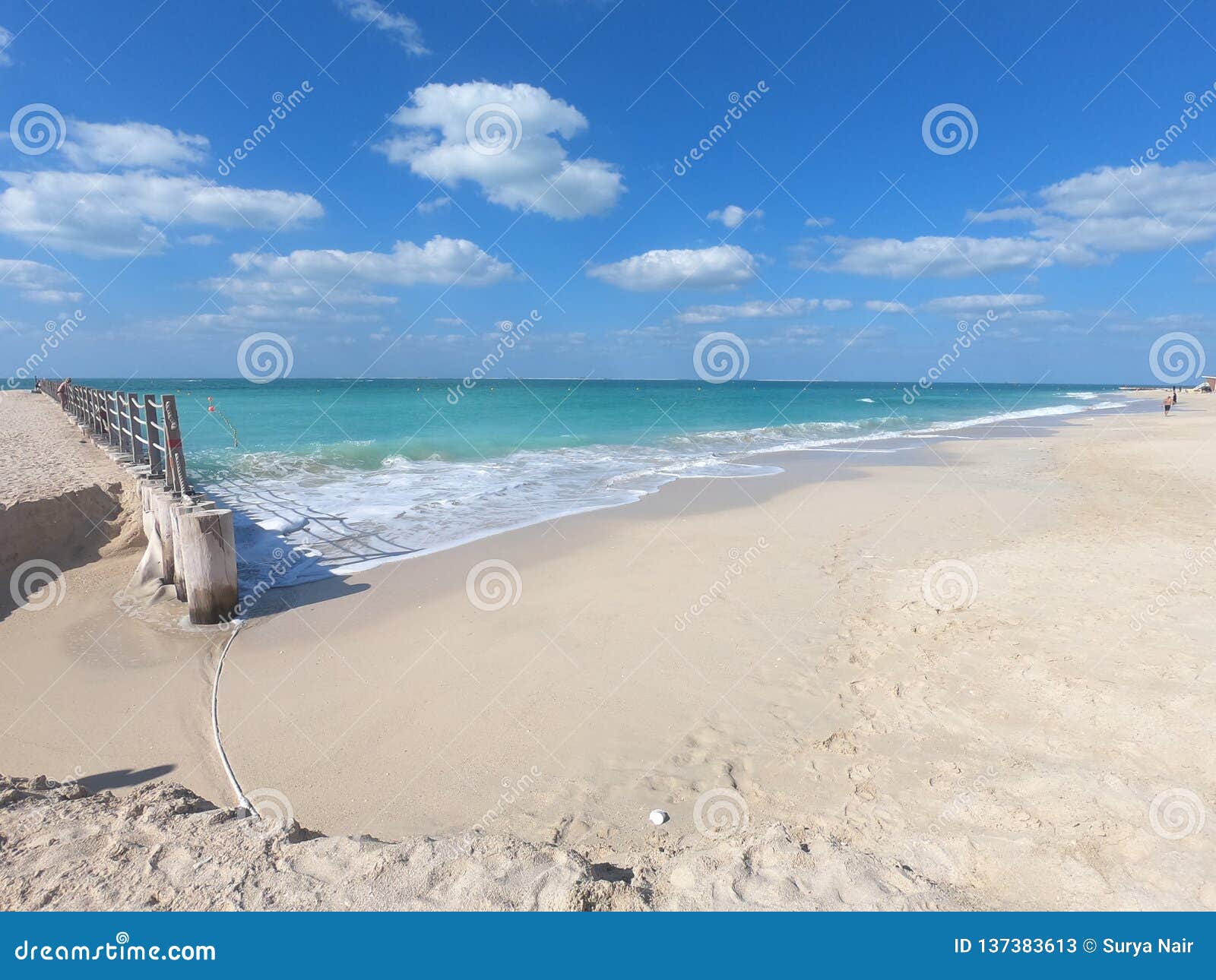View of Pier at Beach in Dubai with Clear Blue Water and White Sand