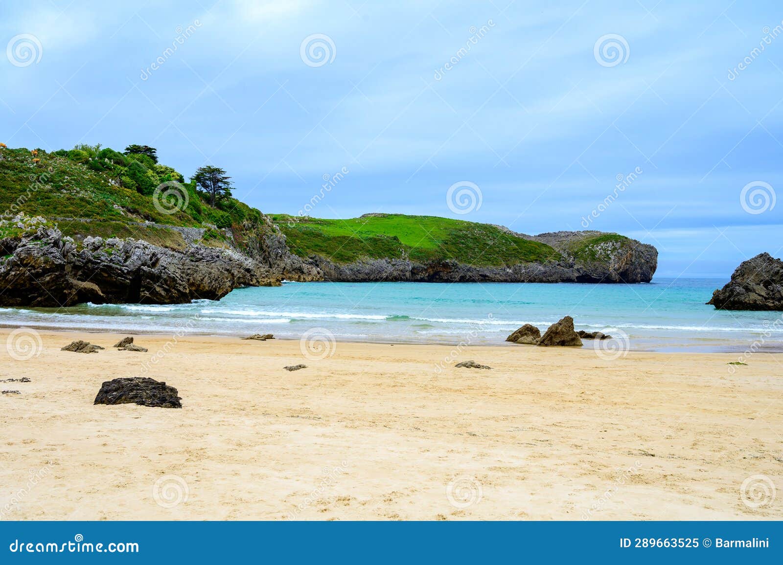 view on playa de borizo in celorio, green coast of asturias, north spain with sandy beaches, cliffs, hidden caves, green fields