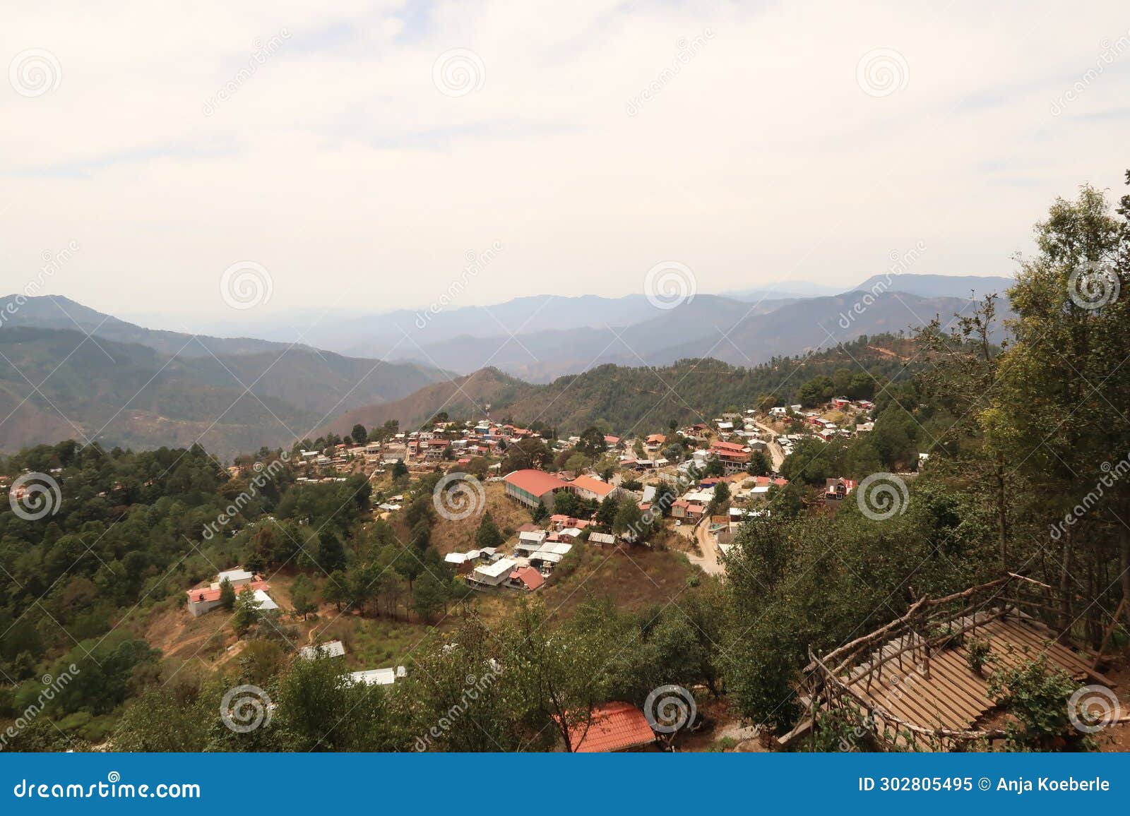 view from a view point mirador onto san jose del pacifico, a small village in oaxaca, surrounded by a dense forest and hills,