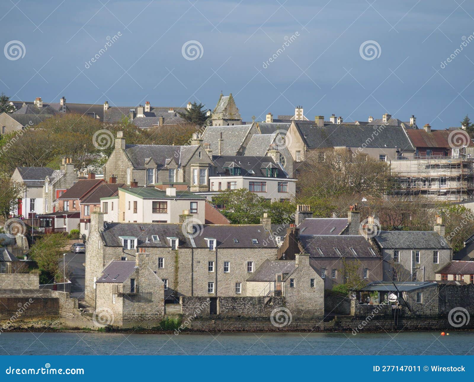 view of a rural city situated in the shetlands islands of scotland, nestled near a body of water