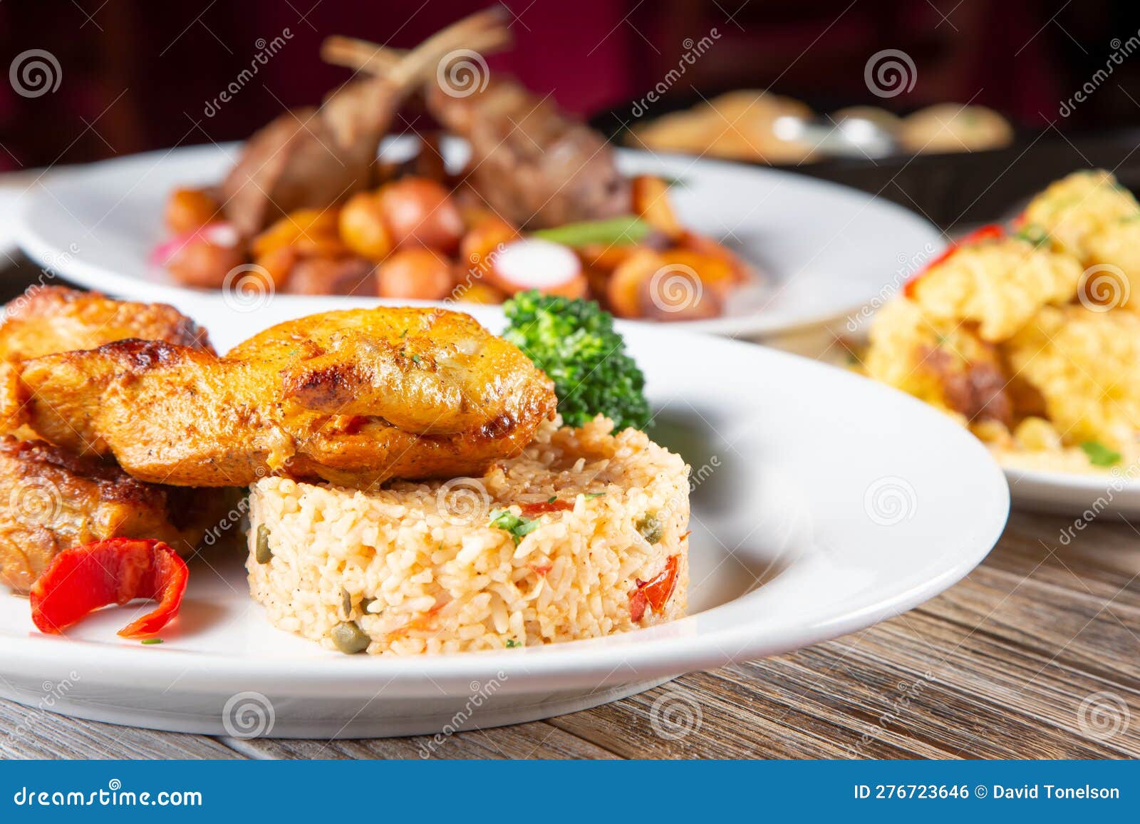 Entrees on Table, Roasted Chicken, Rice, Indian, Spanish Stock Photo
