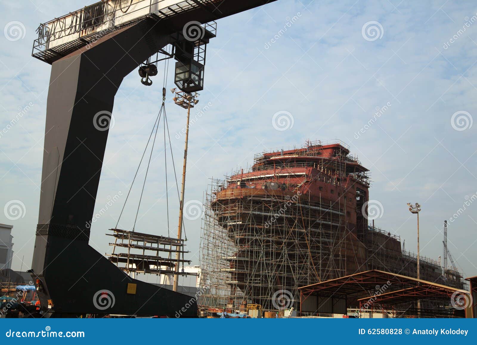 view of shipyard with straddle crane and ship under construction