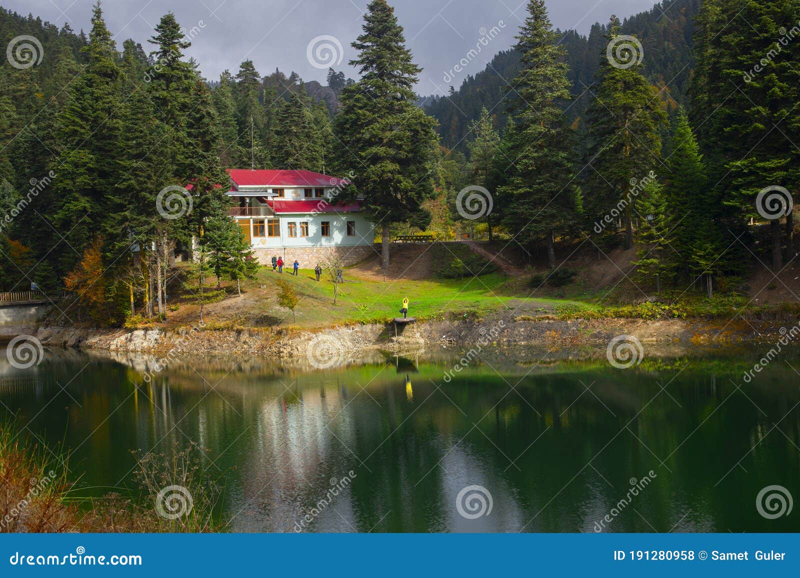 view of small akgol lake in ayancik, sinop around big mountains with high pine trees on cloudy sky background.