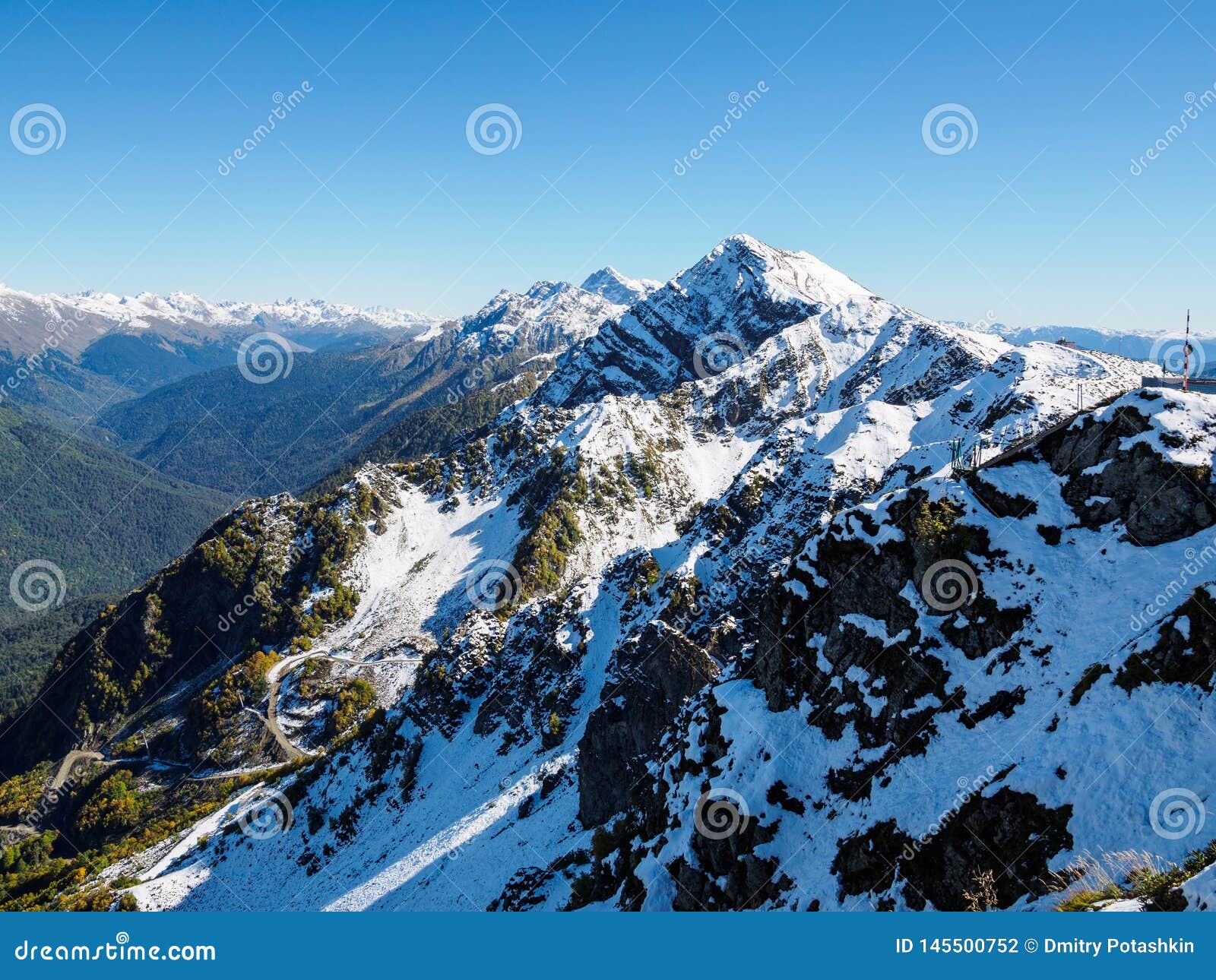 View Of The Snow Covered Mountain Range And The Green Valley In Front