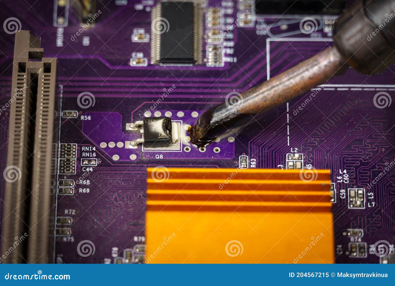 View of the Soldering Iron Tip and the Purple Computer Motherboard