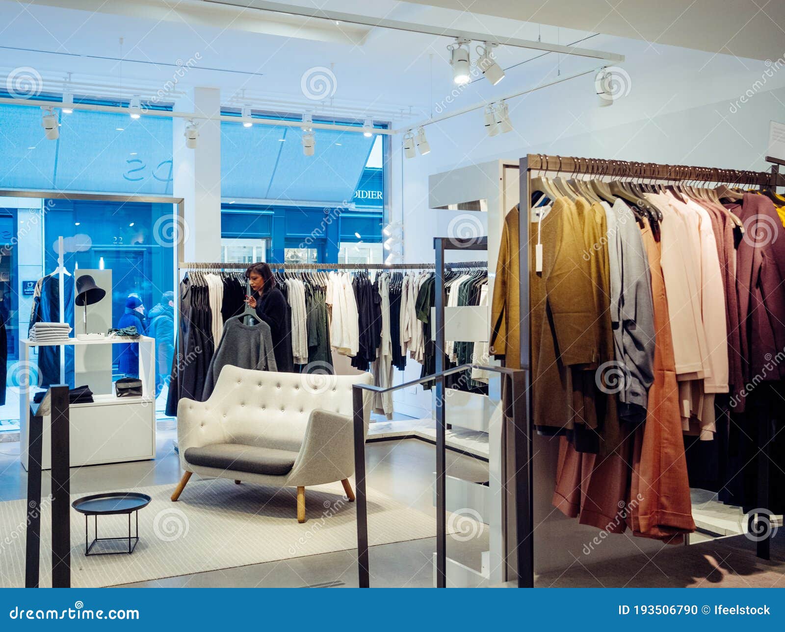 View from the Street of a Woman Shopping Inside Clothes Store with ...