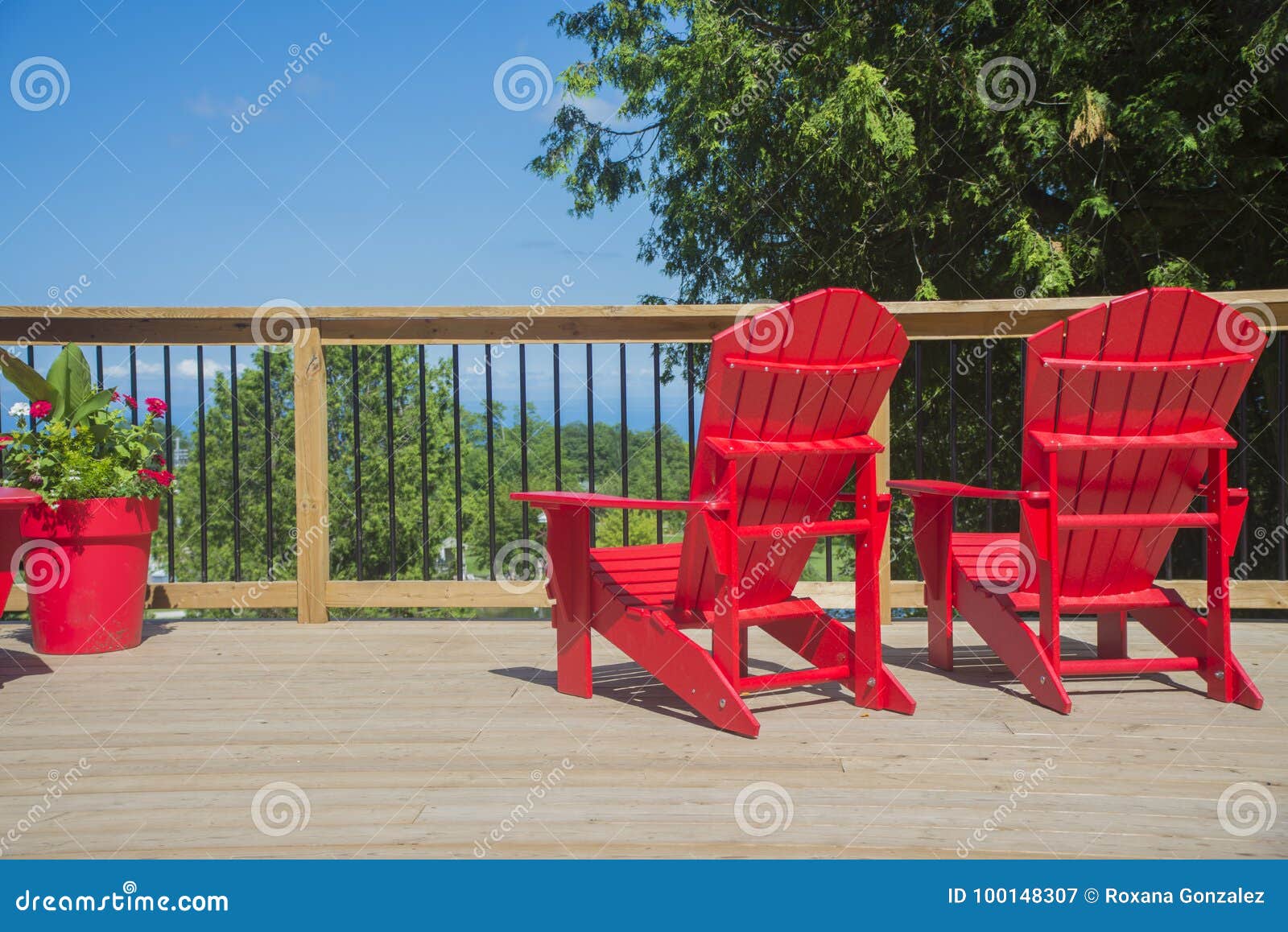 view of typical canadian red muskoka chairs on a wood deck