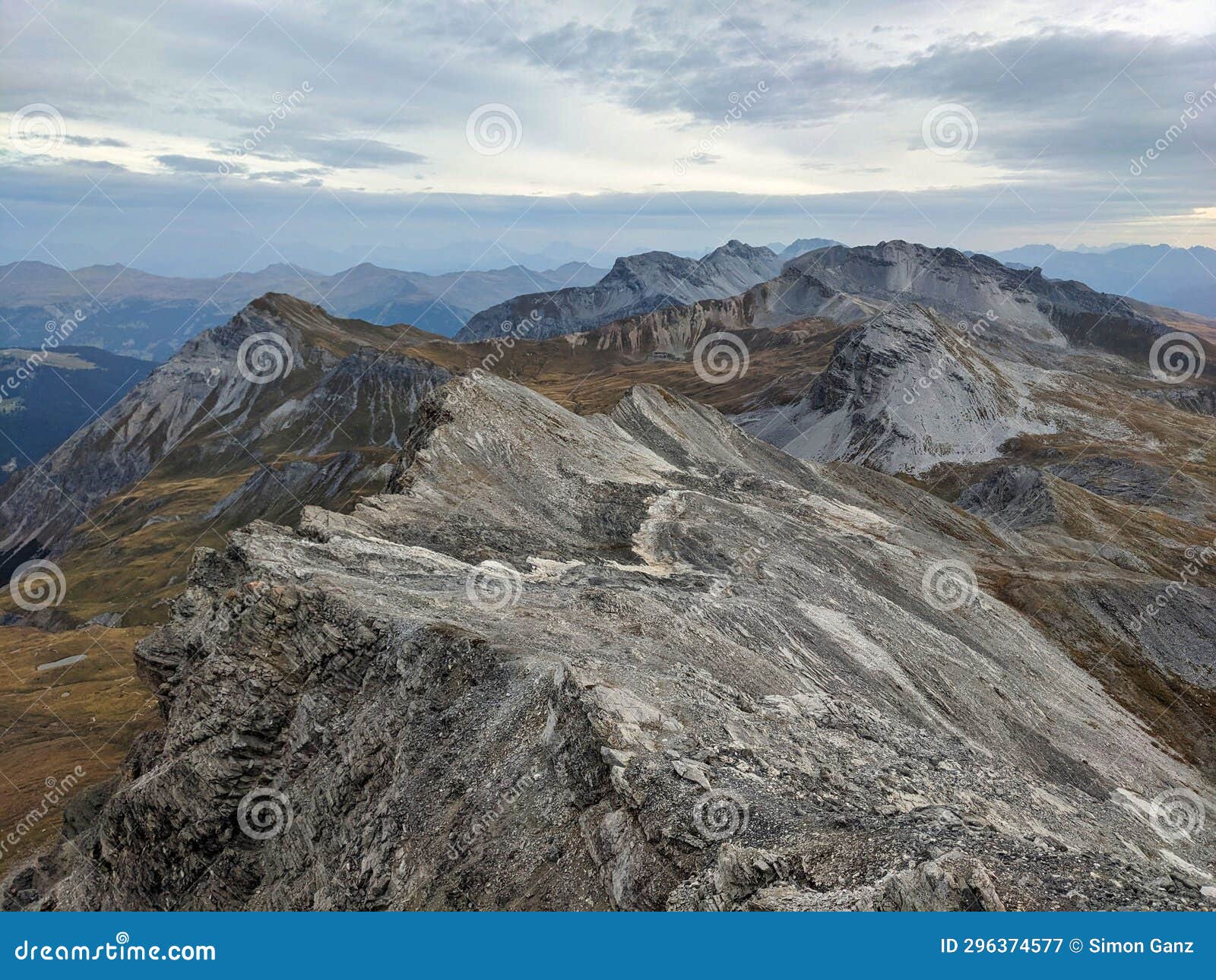 view from the valbellahorn mountain in the plessuralps. hiking under a cloudy sky with a view of the strela range davos.