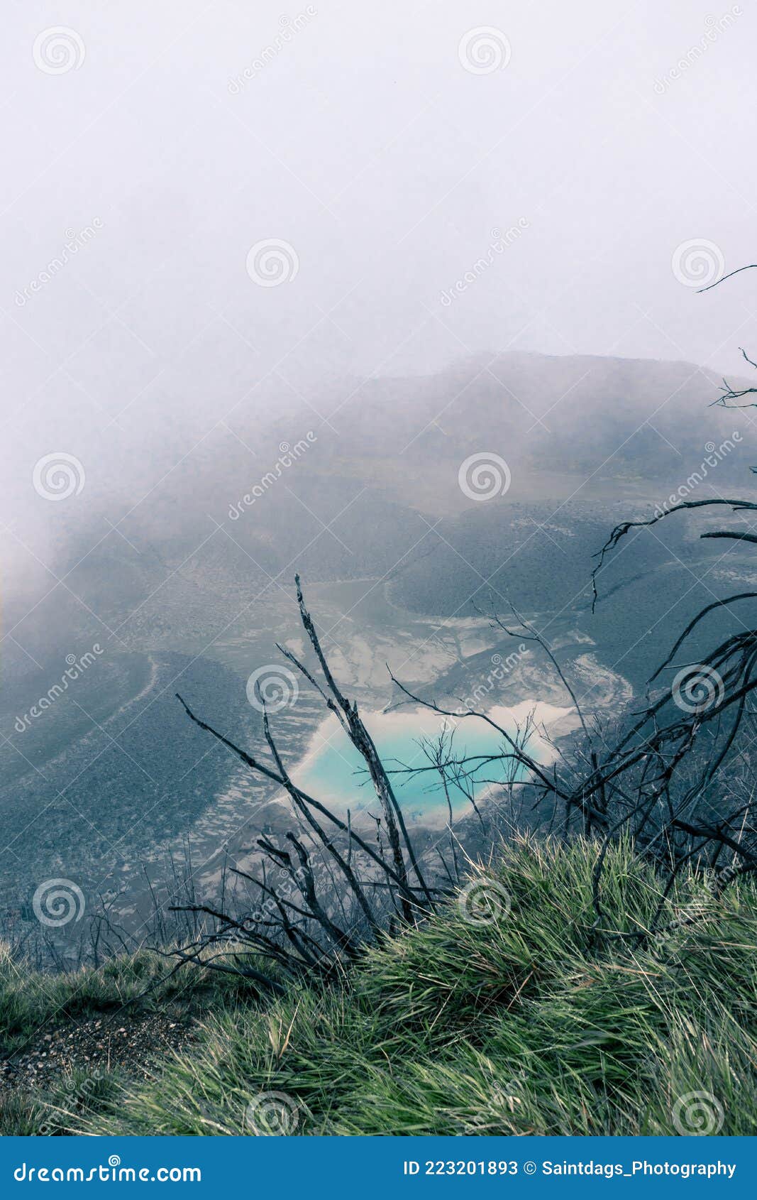 view of the viewpoint of the turrialba volcano national park where you can see a turquoise volcanic lagoon on a foggy day near the