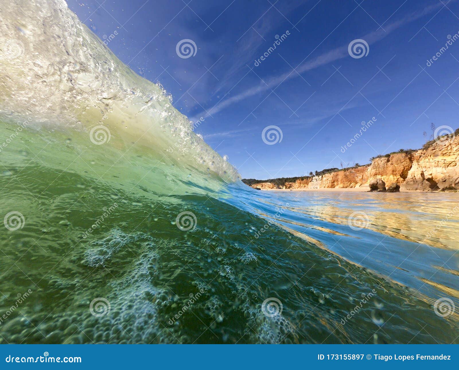 view of a waver breaking at the beautiful alemao beach in portimao, algarve
