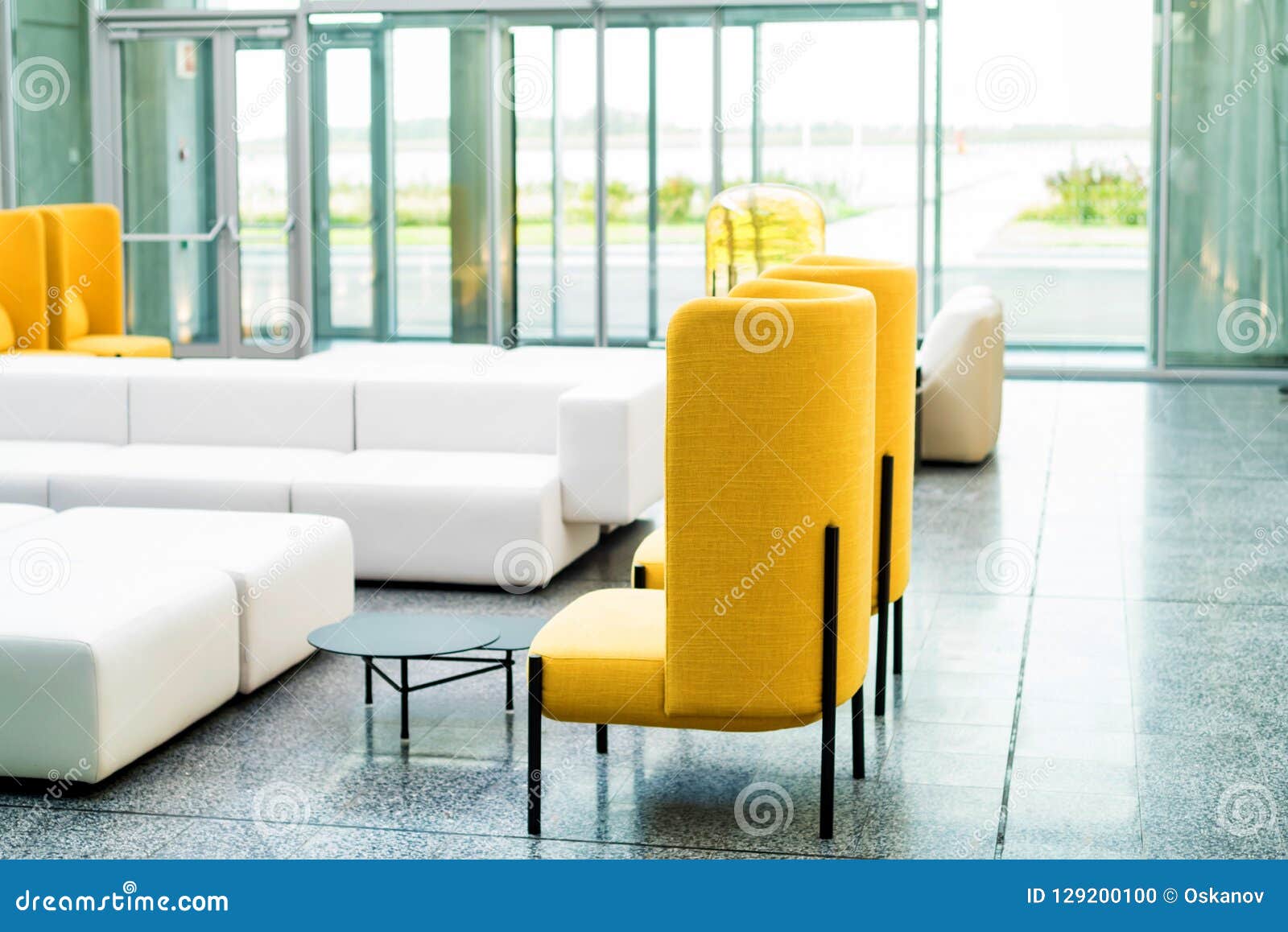 Office Waiting Area Interior with White Sofas and Yellow Chairs Stock