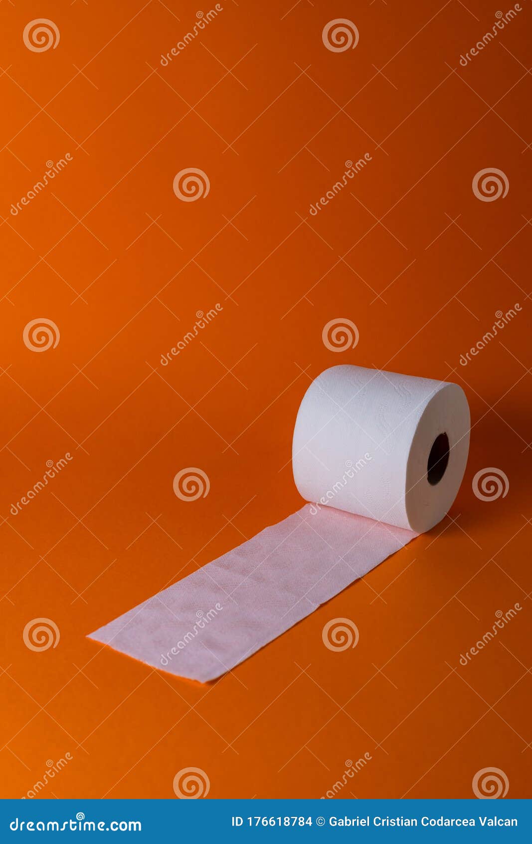 view of a white toilet paper roll over an orange background