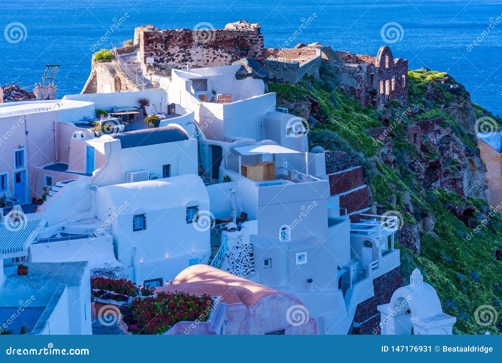 view of whitewashed buildings and byzantine castle ruins in oia