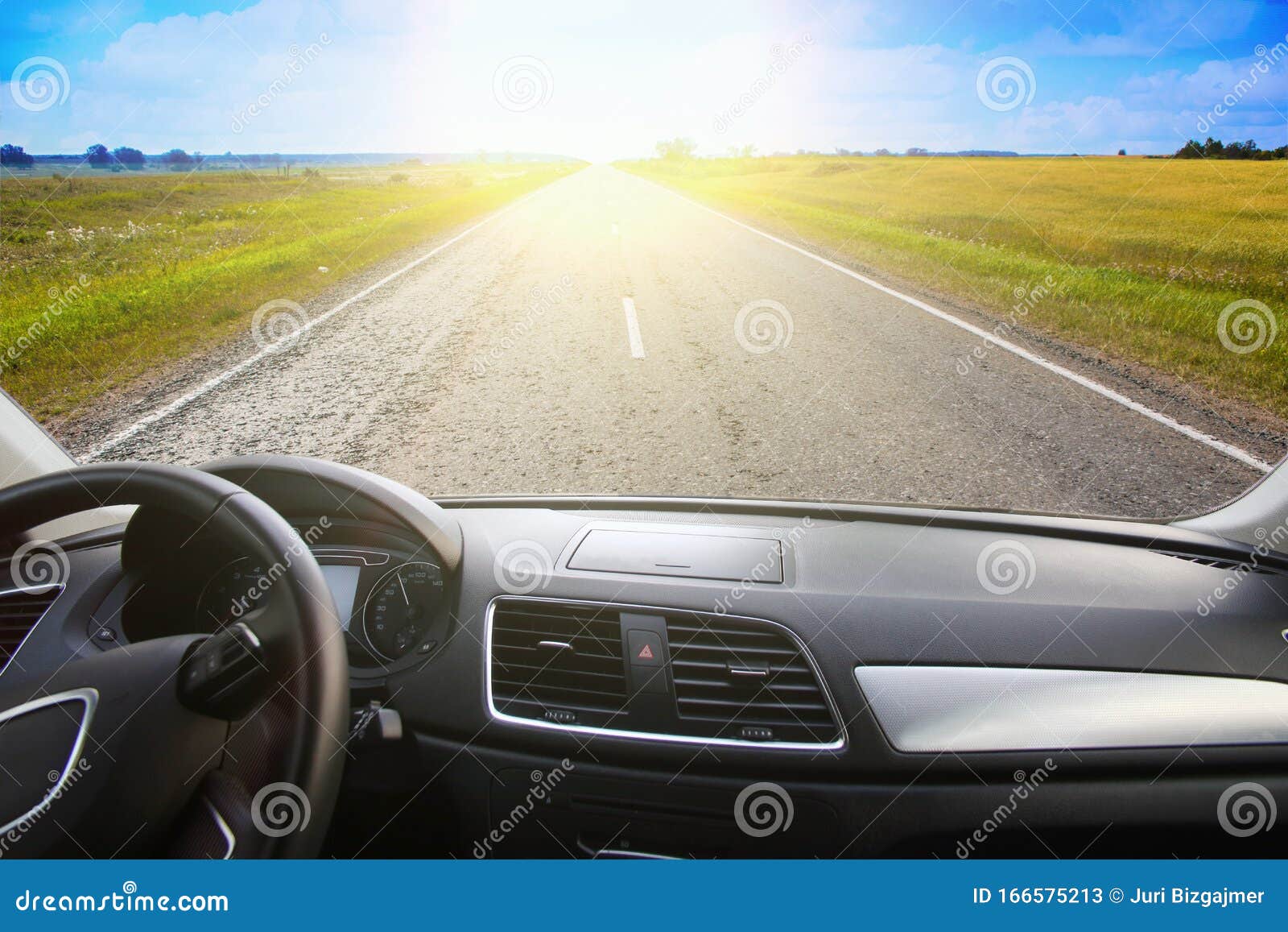 View from the Windshield of a Car Driving Along a Sunset Road Stock
