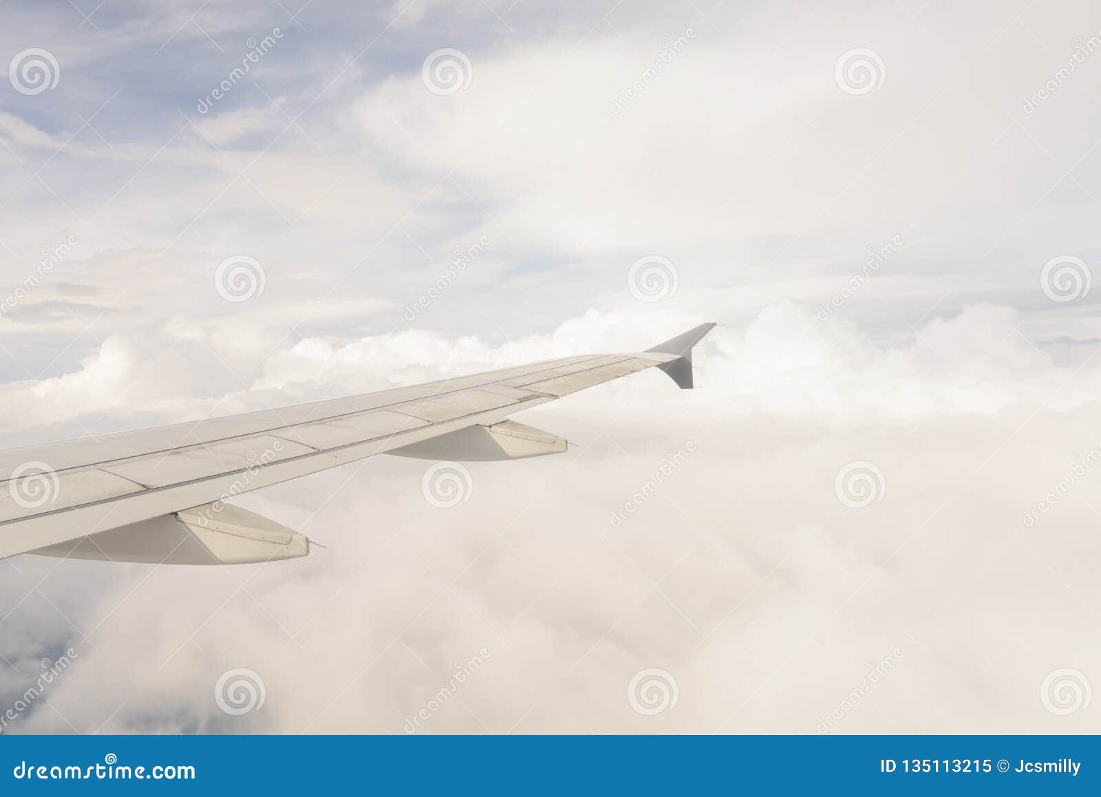 aerial view of wing from jetplane blue sky and big white cloud background